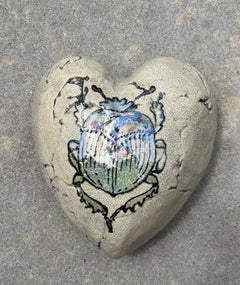 Escarabajo, corazón de Raku firmado por el artista Chris Reilly. Azul iridiscente, gris, tostado