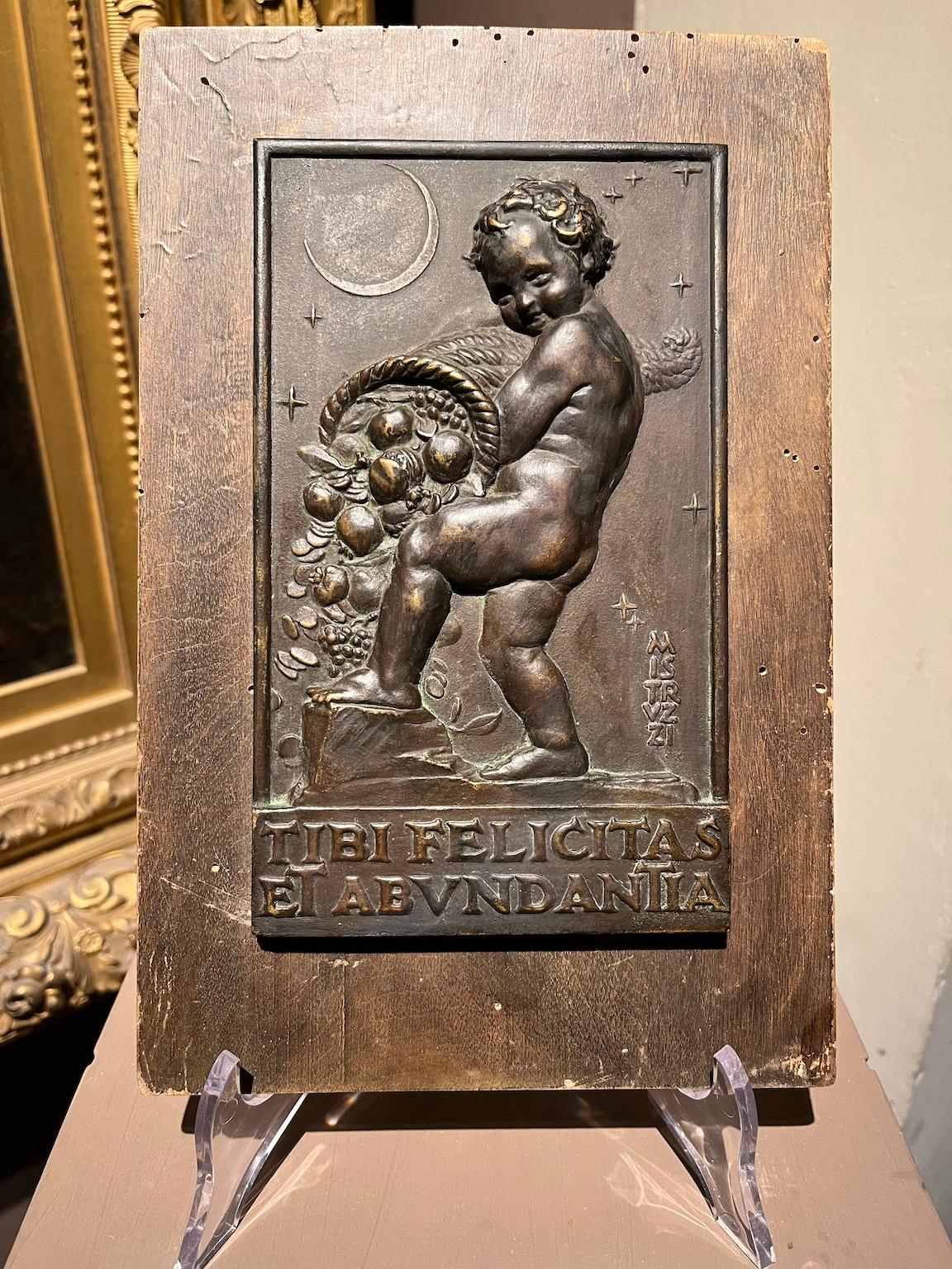 Allegorical bas-relief in bronze and wood with putto and cornucopia