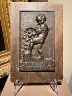 Allegorical bas-relief in bronze and wood with putto and cornucopia