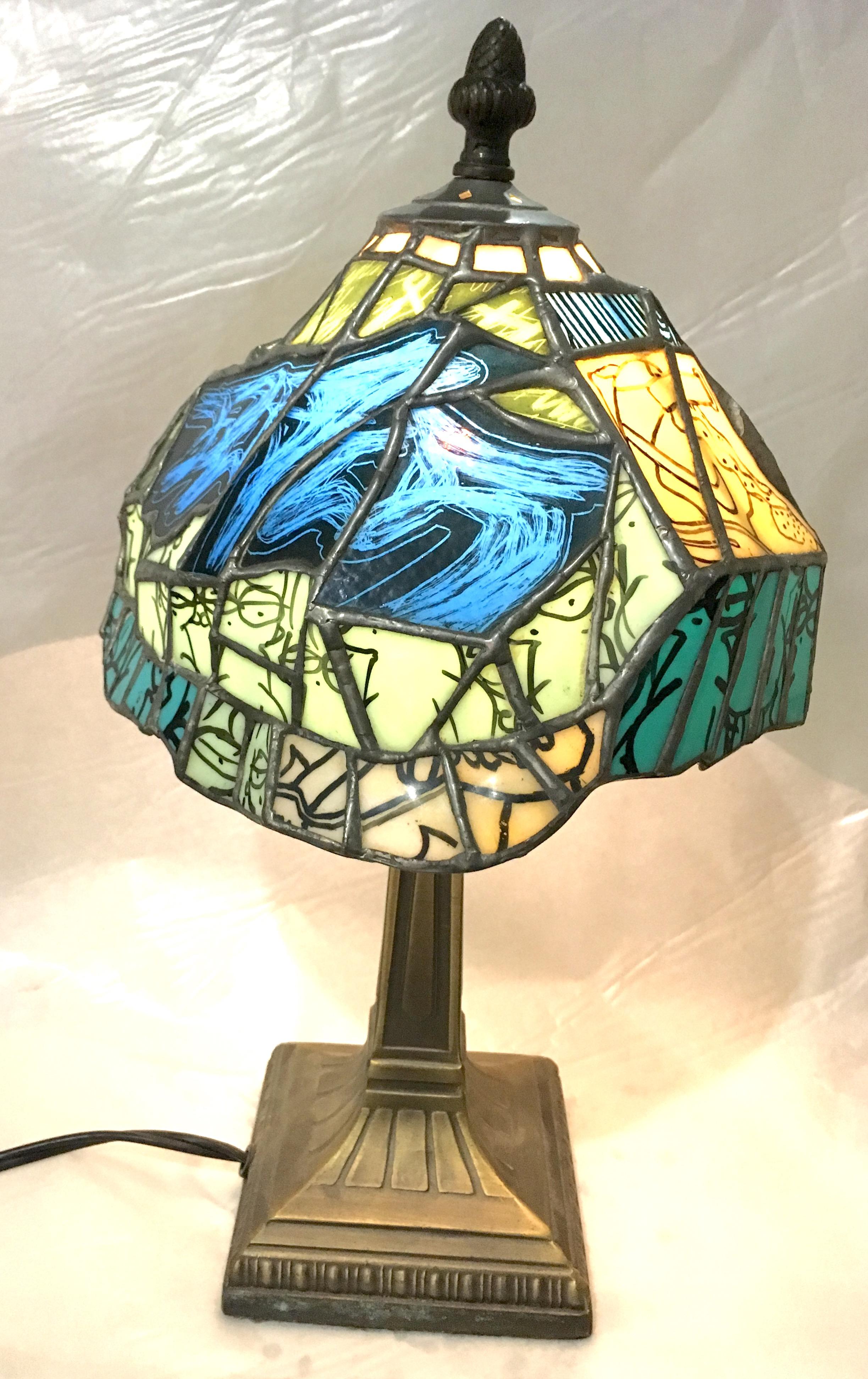 Handcrafted by TF Dutchman, Secret Stash is a one of a kind original Tiffany style stained glass lamp. Brilliant blues, yellows, turquoises and greens are enhanced by kiln fired vitreous painting on the glass pieces. Elements of graffiti and sneaker