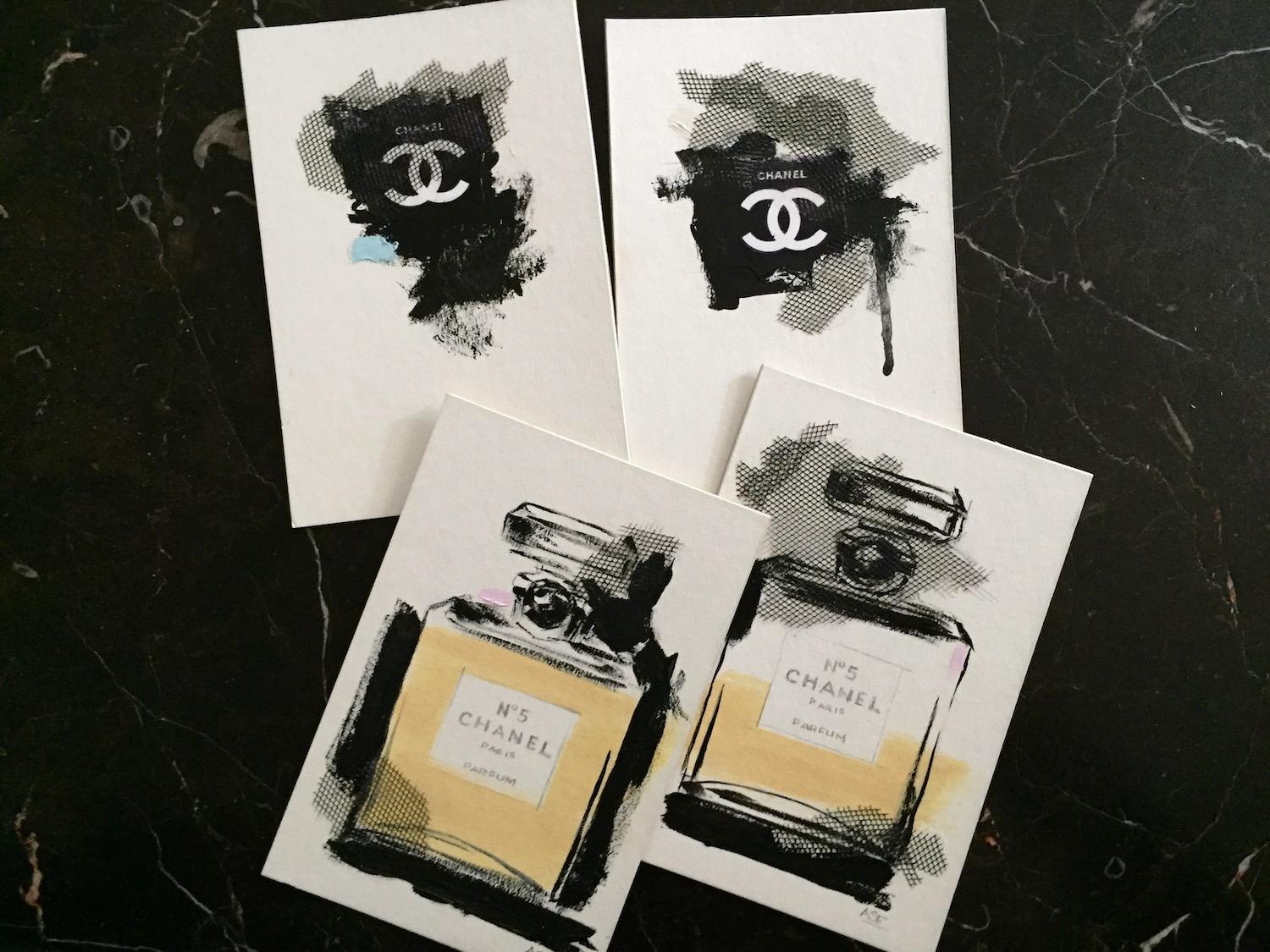 Eine Hommage an das kultige Parfüm Chanel No. 5. Texturierte Elemente verleihen diesem Mixed-Media-Kunstwerk auf Karton visuelles Interesse. Zarte Details ergänzen den Schwarz-Weiß-Kontrast mit einem Hauch von Blassblau. 
(Nummer 4 aus einer Reihe