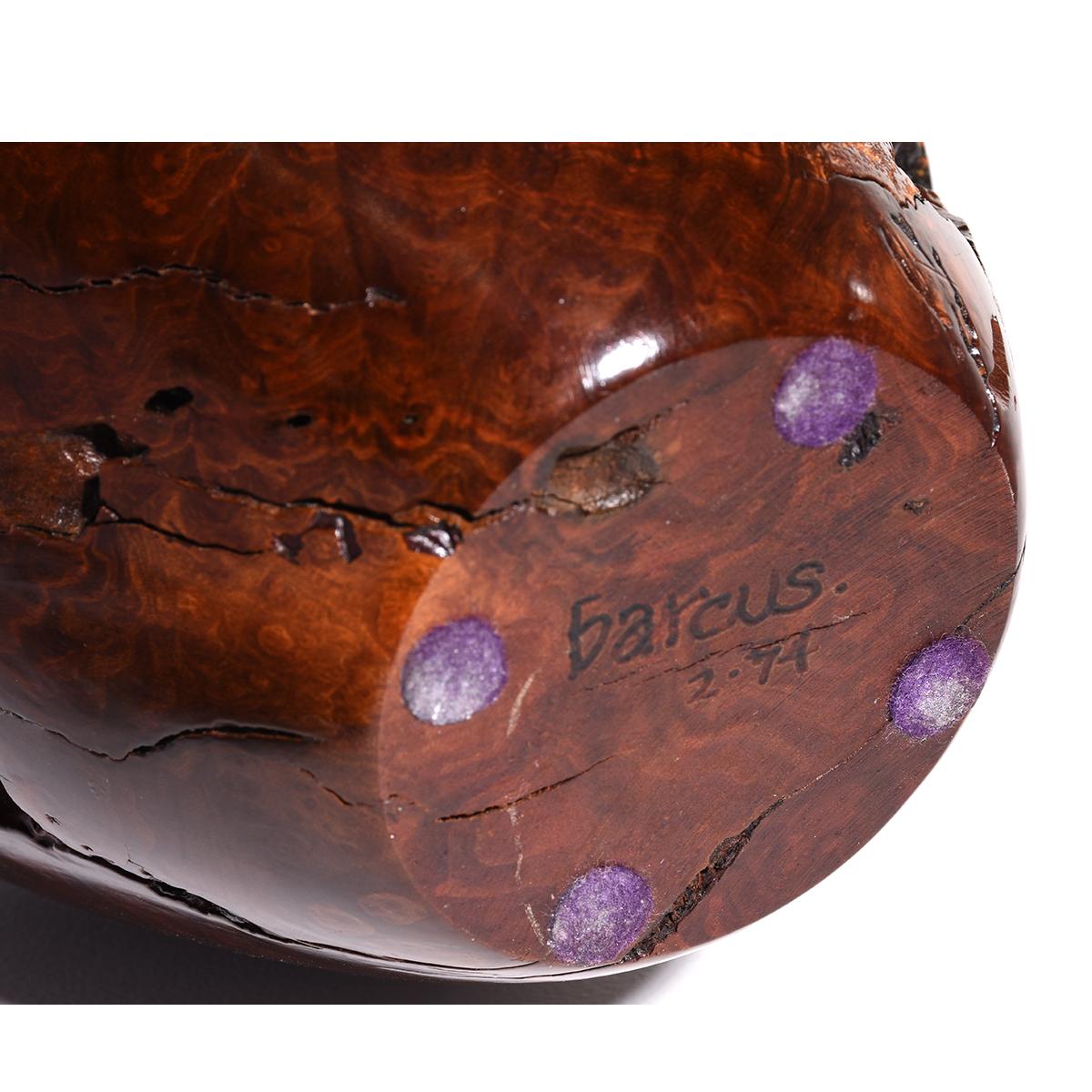 This turned Burlwood vase has rich earth tones with copper highlights. The swirling burl pattern comes through the glossy surface that contrasts with the characteristic rough burl depressions and natural cracks running throughout the piece. The vase