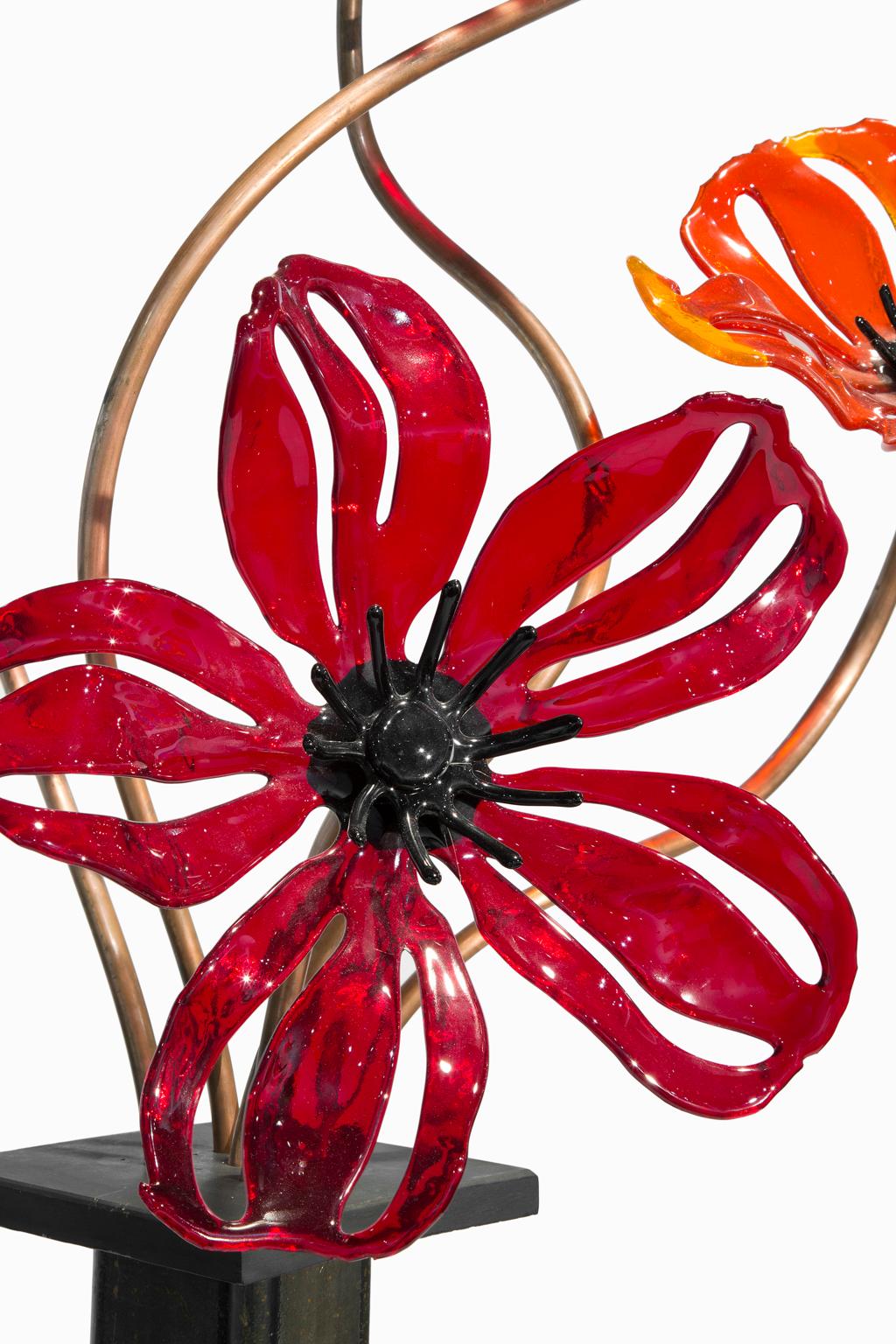“Poppies” is a poetic interpretation of a garden flower rendered in exquisite colored glass by Craig Mitchell Smith. Craig is an extraordinary glass artist who is currently active in his Lansing, Michigan studio. He has changed the way we think