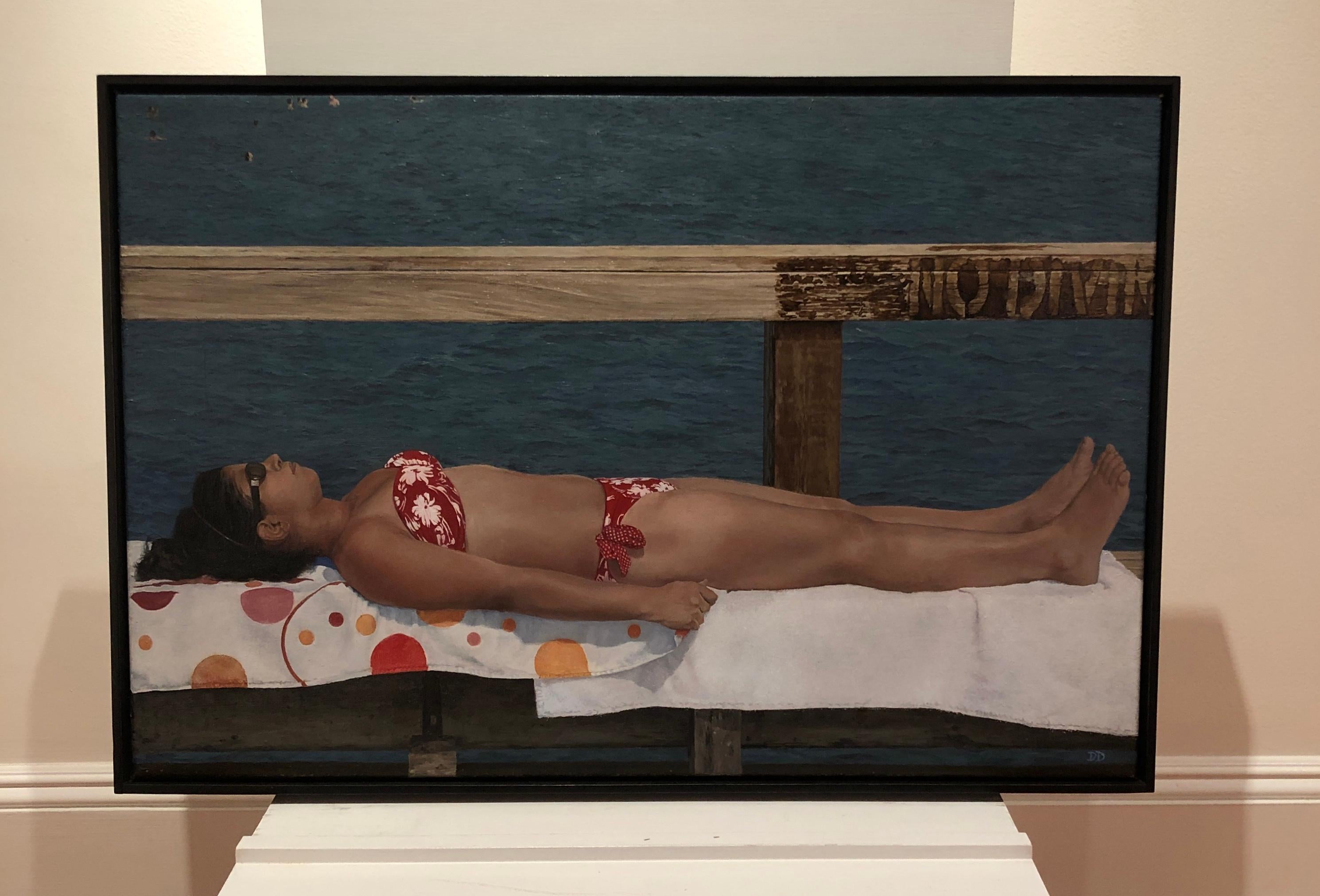 Contemporary realist painting of young woman in a bikini lying on a dock by NY based artist David Desimone. FRAMED dimensions are 21 x 31 inches, black floater frame.
DeSimone paints in oil on canvas, focusing primarily on landscapes depicting