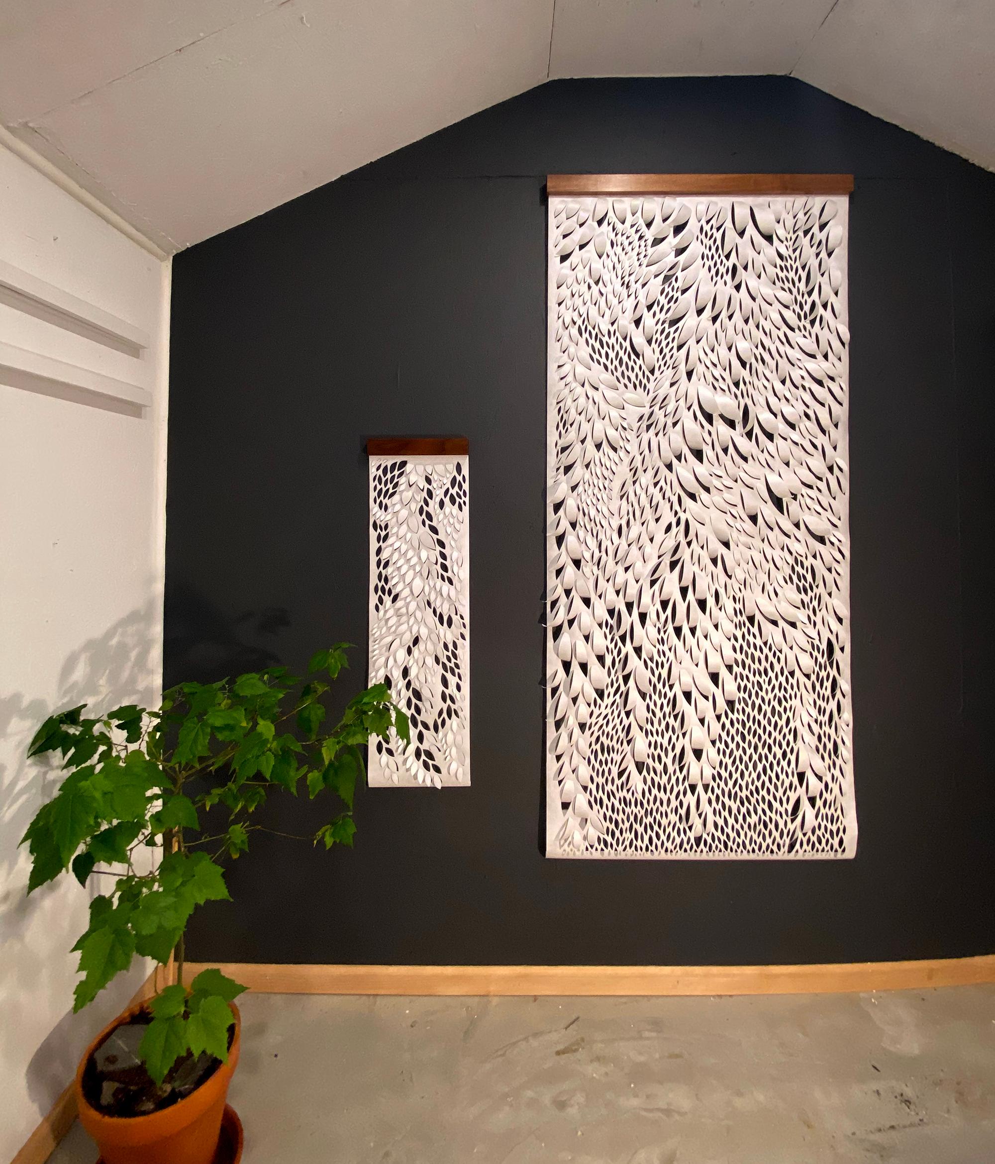 White organic, leaf like shapes create a fluid hanging natural sculpture.  Each wall hanging is hand-cut (not laser) out of Tyvek, a synthetic paper that is incredibly durable. These pieces are dust, water, mildew, and tear resistant. The hangers
