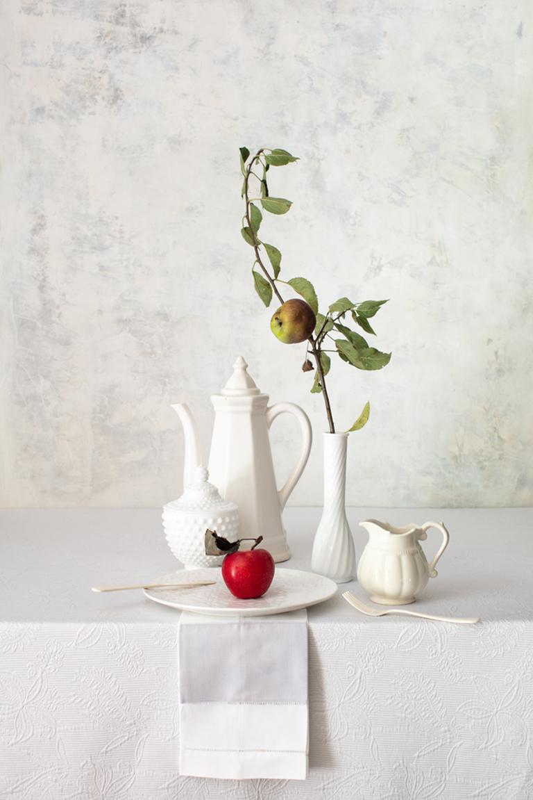 Yelena Strokin Still-Life Photograph - Off White 7 - Still life table tea setting w/ red apple & branch in vase