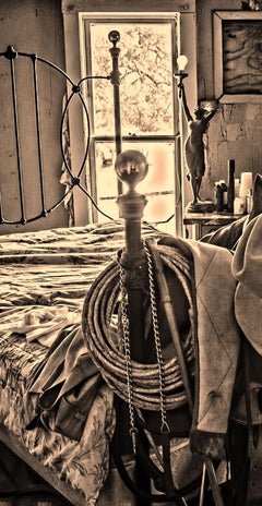 Bunkhouse - Sepia tone cowboy hats, saddle, & riding gear on bed frame, interior