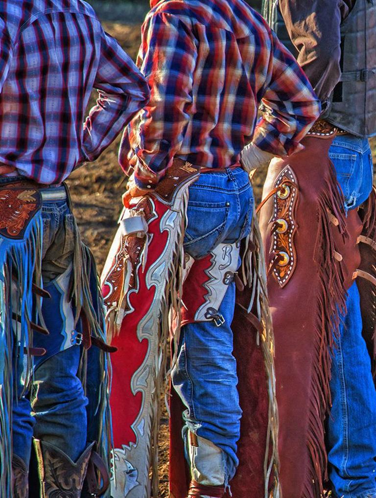 Chaps Rock Springs - Cowboys lined up, colorful fringe chaps & blue jeans - Photograph by Mike Marvins