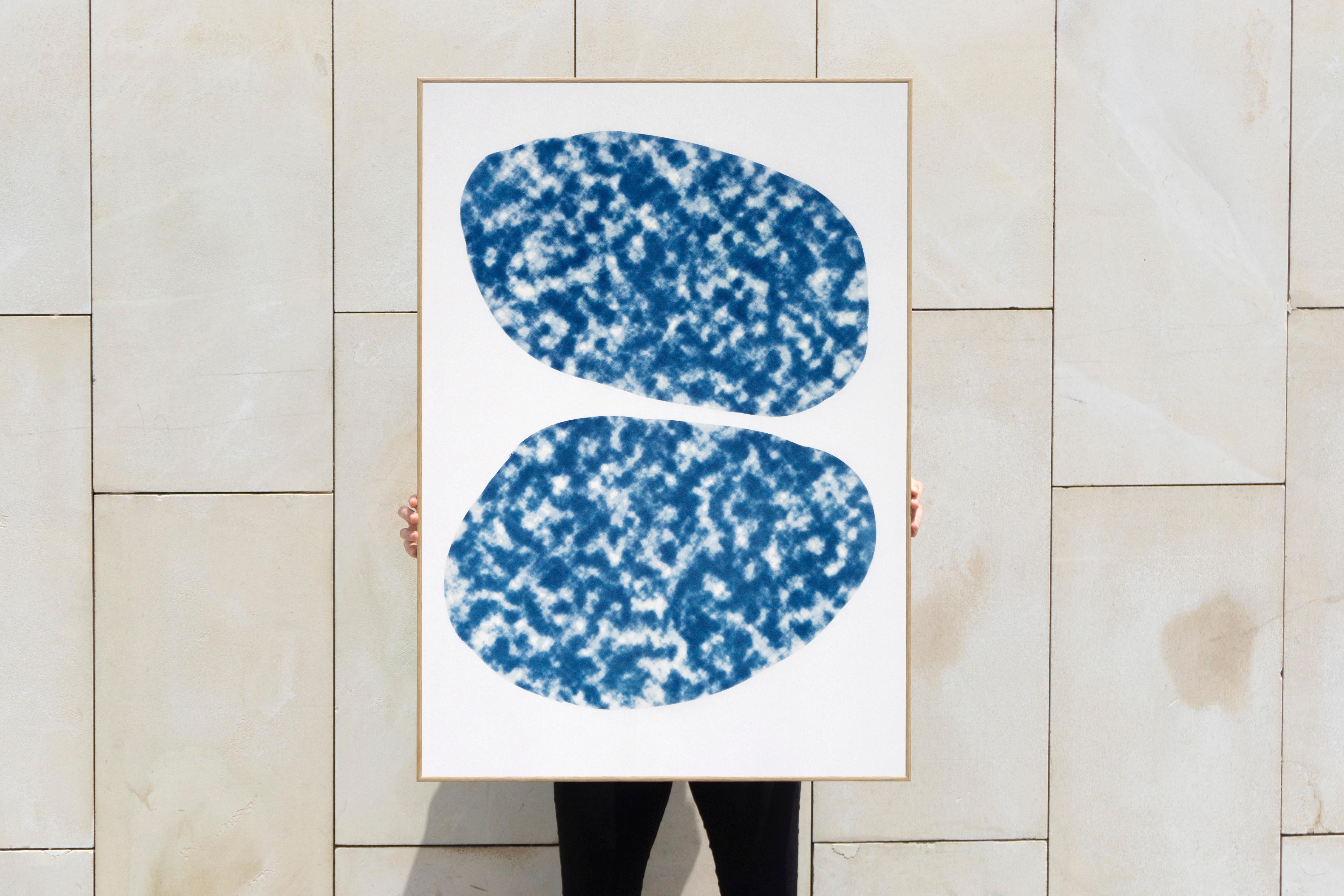 This is a unique cyanotype print of two abstract cloudy ovals. The emulsion was hand-painted and exposed using a textured photo negative. 

Frame is for illustrative purposes only, artwork is sent carefully rolled in a tube. 

Details:
+ Title: