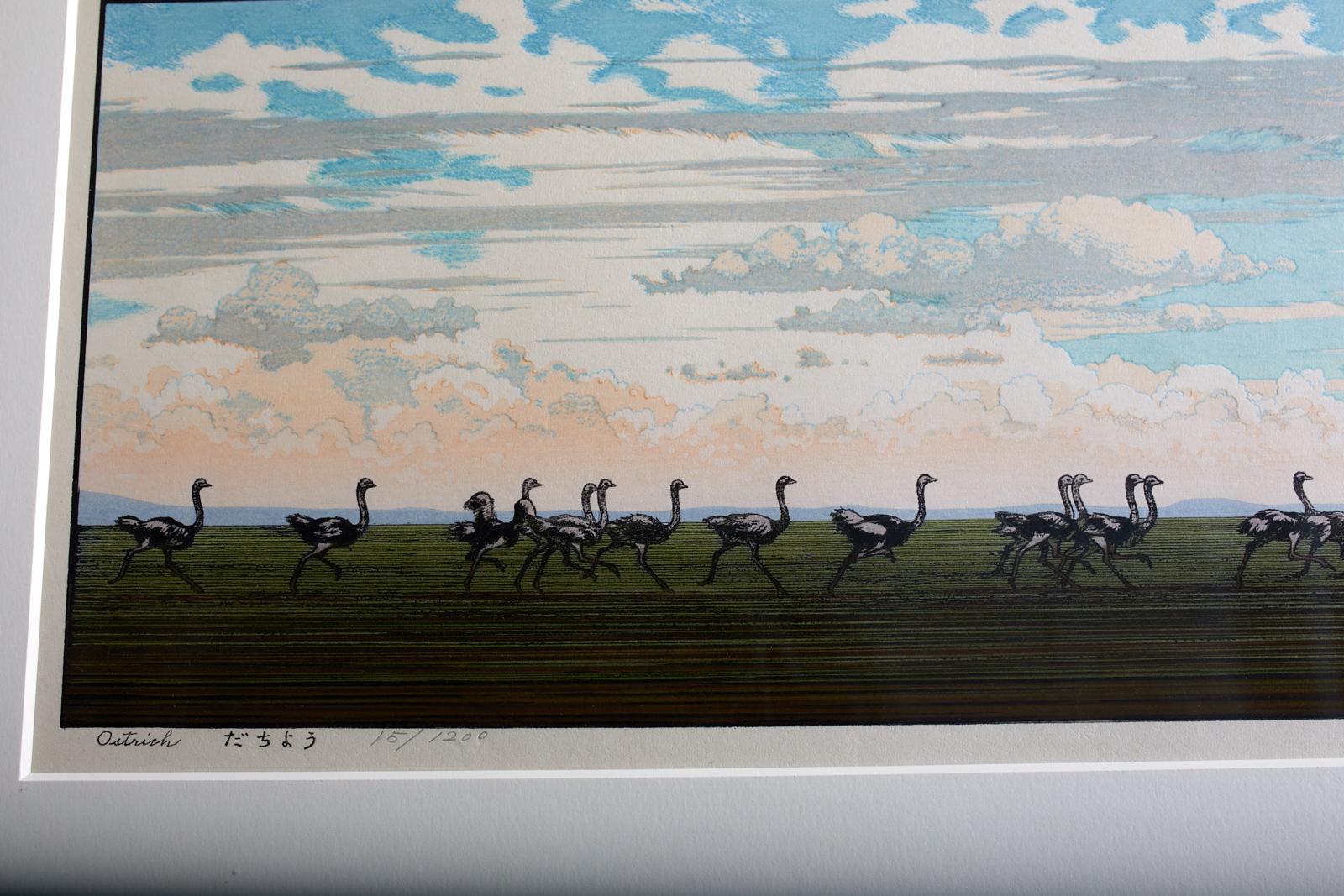 Idyllic landscape wood block print by Toshi Yoshida (Japanese 1911-1995). Depicts a savanna style landscape with ostriches beneath a dramatic sky titled on left in pen and numbered in pencil 15/1200. Pencil signed and dated on right. Set in a