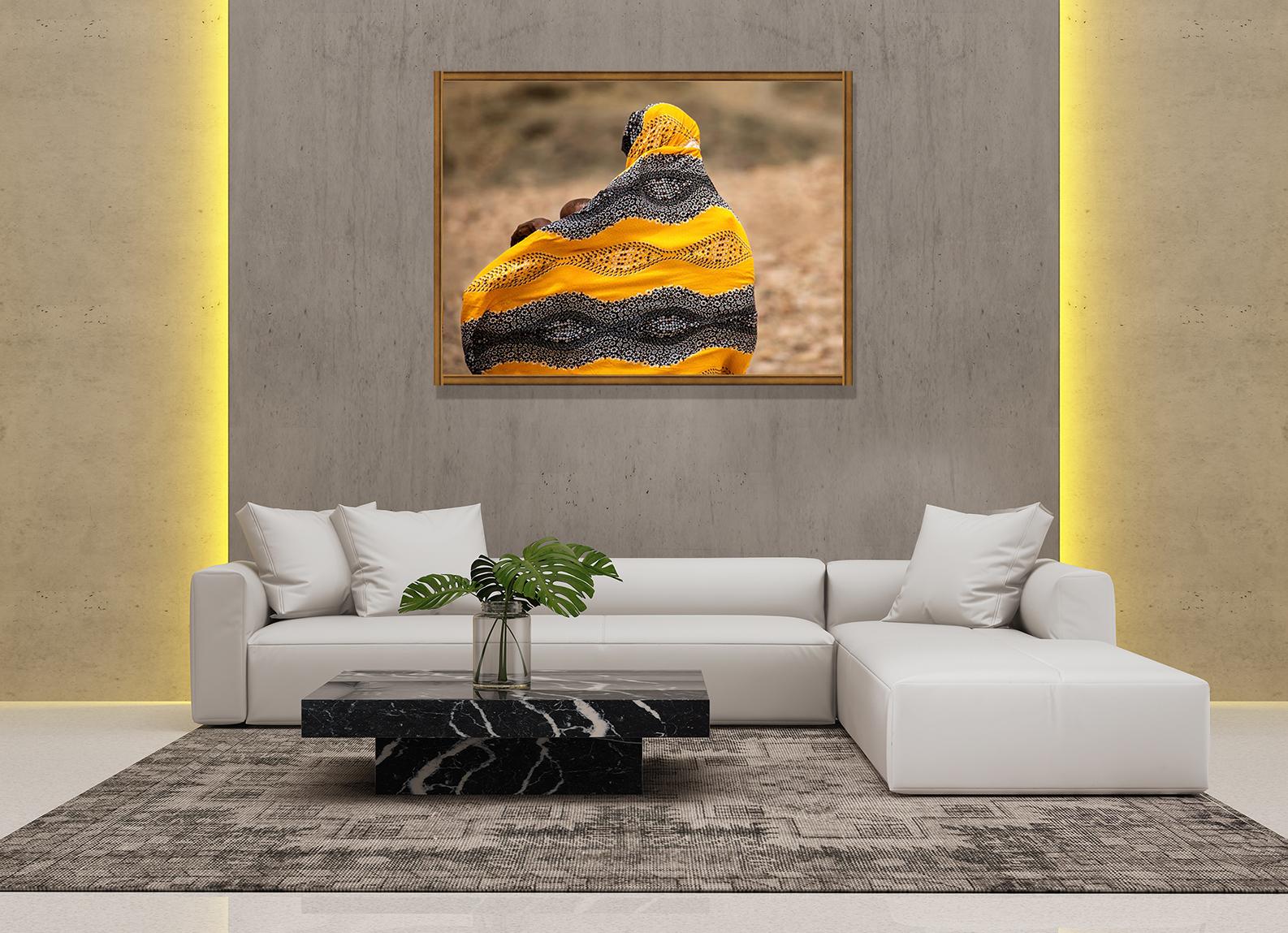 This fine art print features back of a woman wearing Yellow-Gray scarf, holding two of her babies. This image was shot by Dorte Verner in Djibouti, East Africa, one of the warmest and driest cities in the world. 

Dorte Verner shot this photograph,