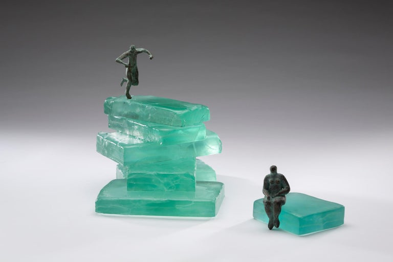 Worth the Climb was created using casted glass and lost wax bronze.  The glass and metal were cold worked and bronze figures are patinated.  Worth the Climb is two pieces. The glass on the smaller second piece with figure has been cold worked