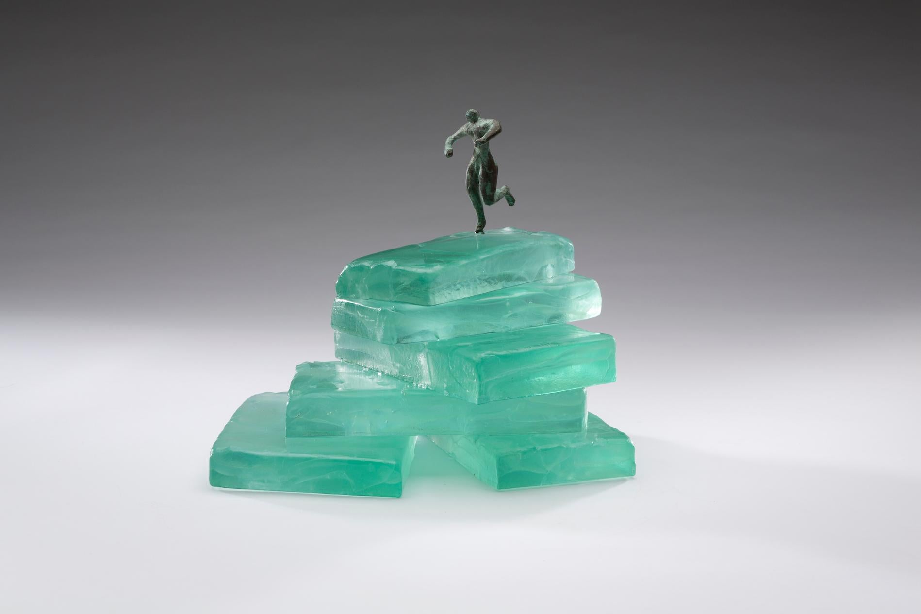 Worth the Climb was created using casted glass and lost wax bronze.  The glass and metal were cold worked and bronze figures are patinated.  Worth the Climb is two pieces. The glass on the smaller second piece with figure has been cold worked