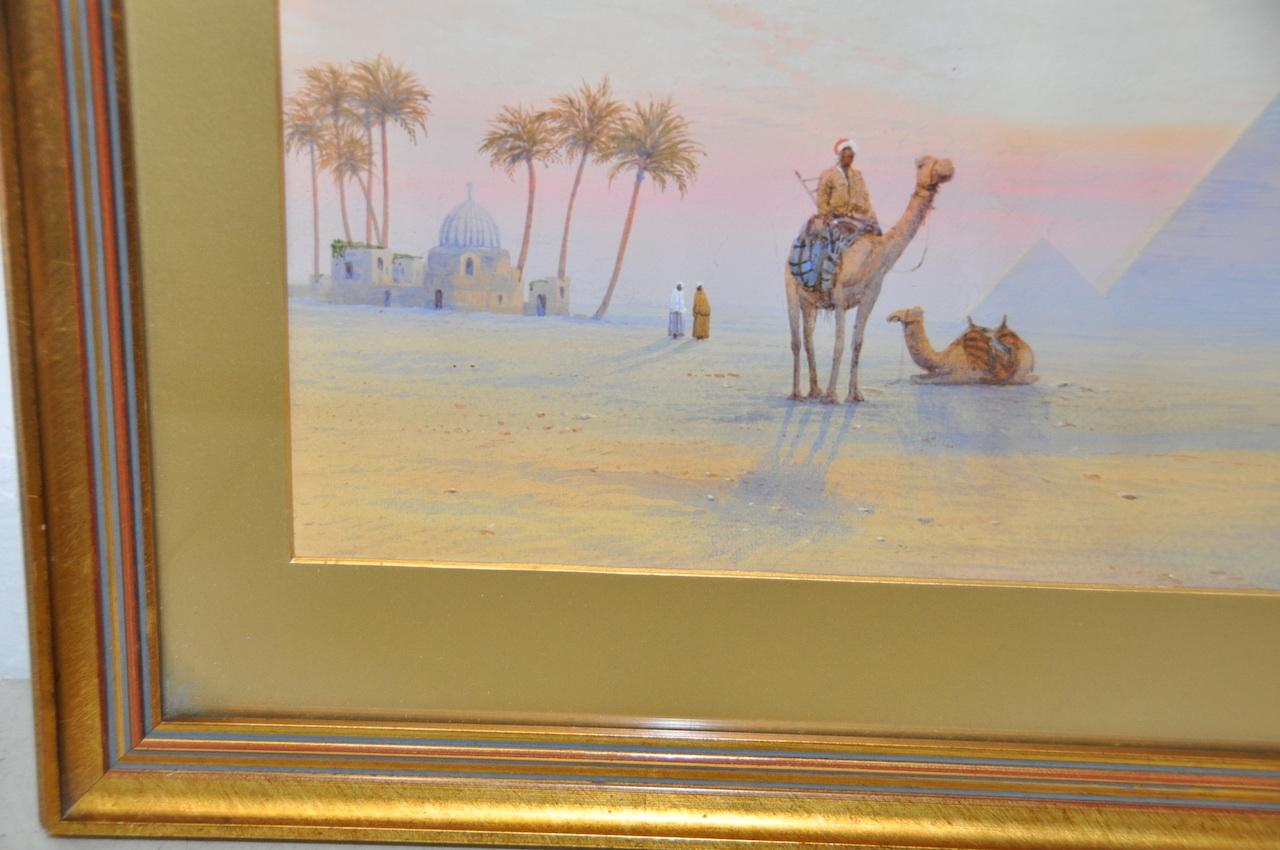 Wonderful original watercolor of the Pyramids at Giza.

Figures and camels stand by the great pyramids at the end of the day. Beautiful blue and pink skies from the setting sun cast long shadows.

Original watercolor on paper. Dimensions 18