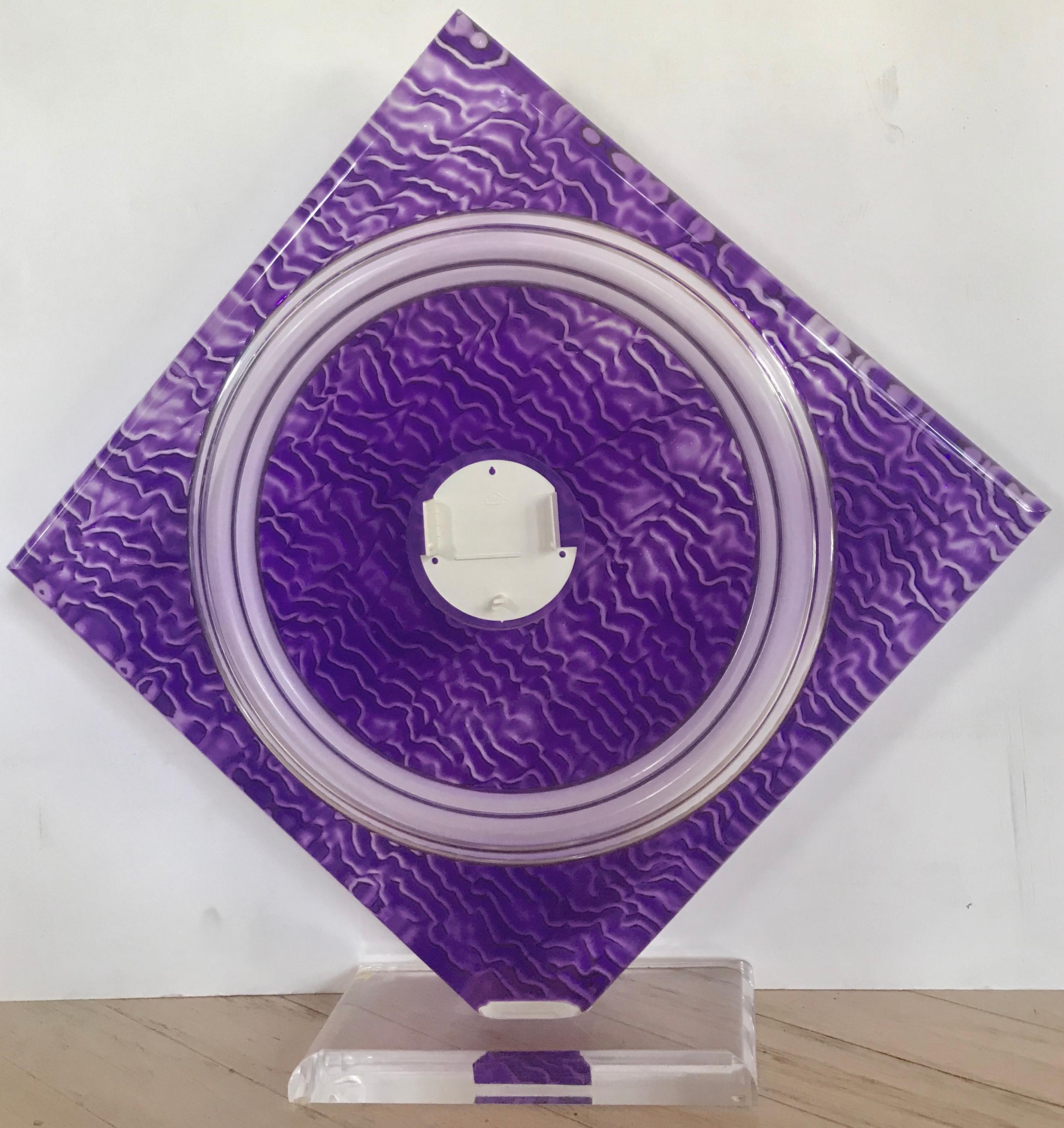 Norman Mercer (American, 1916-2007) Purple Cast Acrylic Sculpture. The amethyst diamond shaped sculpture is mounted on a beveled acrylic base. Cast with a repeating geometric pattern. In the back center of the step formed center circle, is a holder