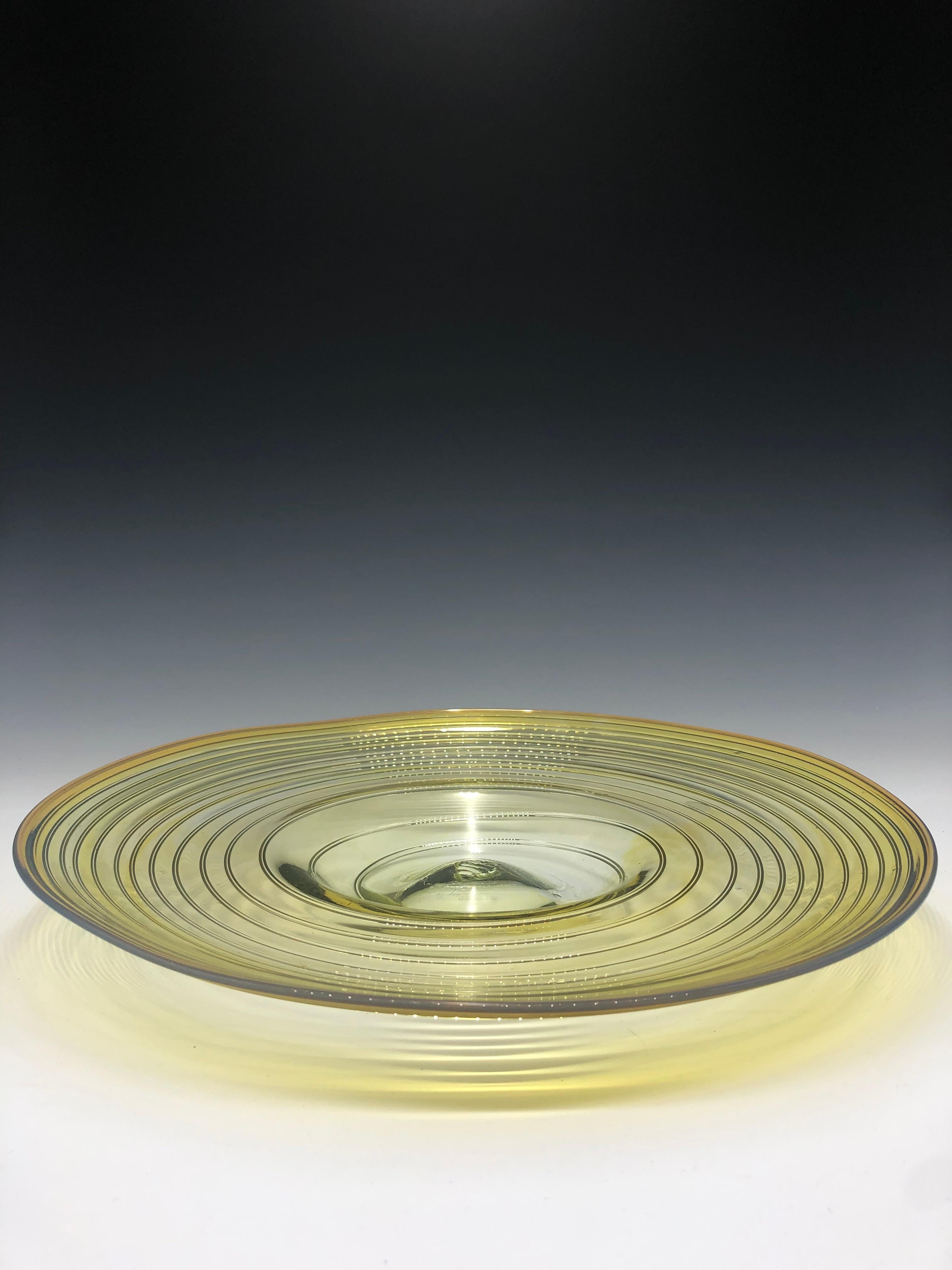 Schöner gelber Glasaufsatz von Peter Bramhall, signiert und datiert 8/2/80. Die Platte mit dem Wirbeldesign ist einzigartig geformt und vollständig mundgeblasen, was eine subtile Pontilmarke auf ihrem Boden hinterlässt. Die Farbe des Glases selbst