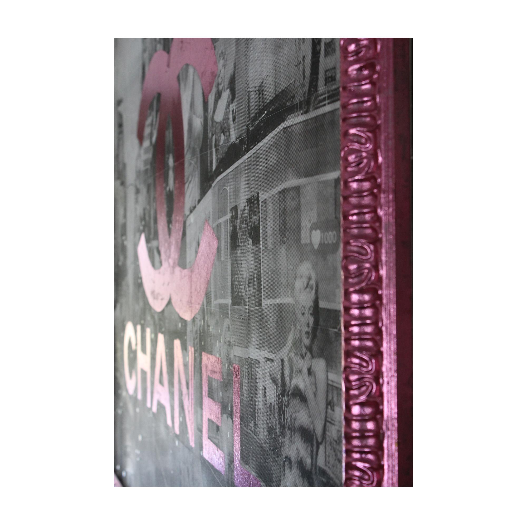 'Pink Sheets' Mixed Media Framed Wrapped Canvas features a pink frame around a black and white cityscape with images of Marilyn Monroe and the Chanel symbol and lettering in pink across the middle. A piece of The Marilyn Addiction collection, this