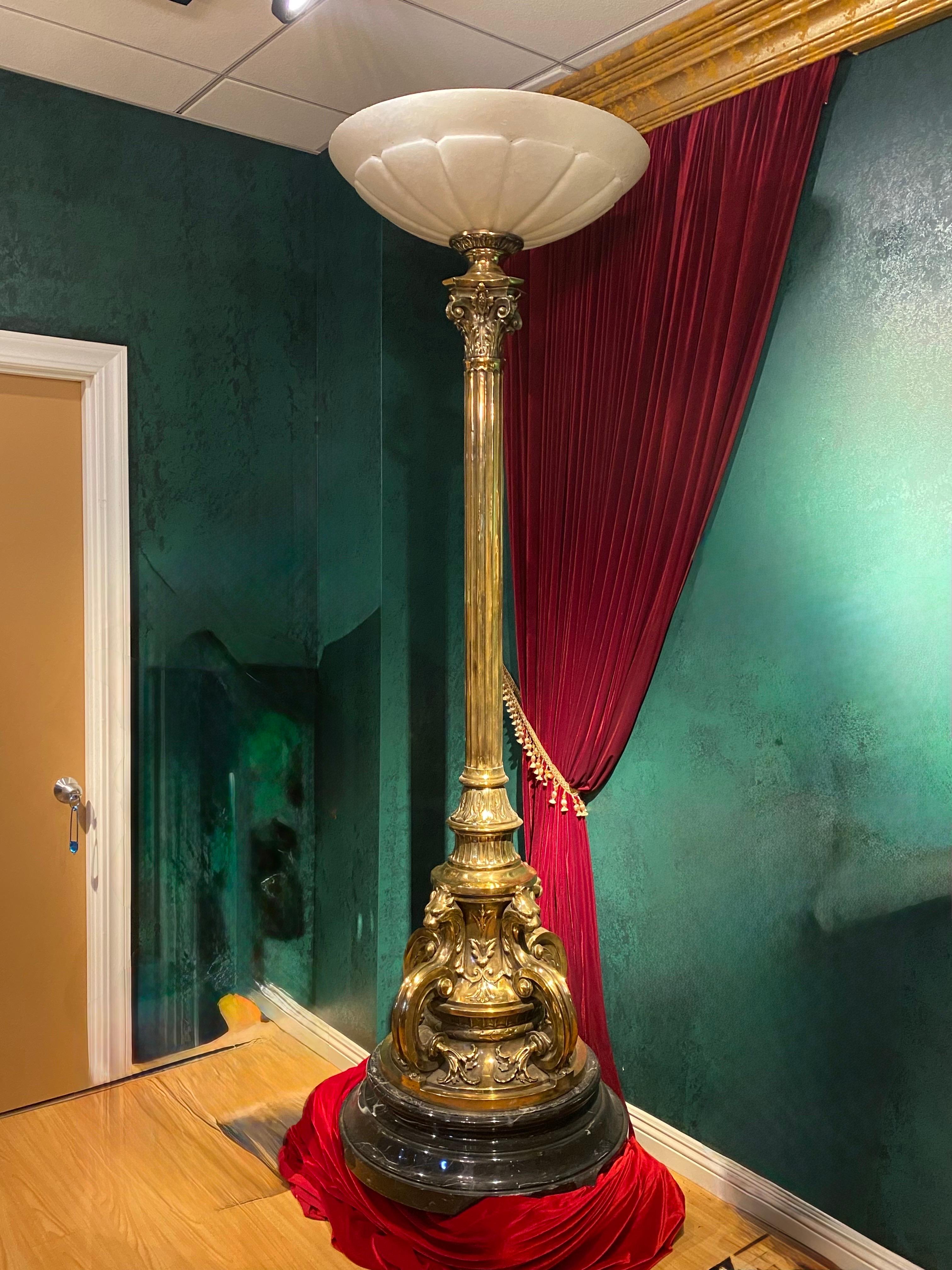 Paire de lampes torchères en bronze doré avec des abat-jours en albâtre sur le dessus et une partie inférieure aux détails exquis, soutenues par une base ronde en marbre sculpté à plusieurs niveaux. 
Mesure :  91