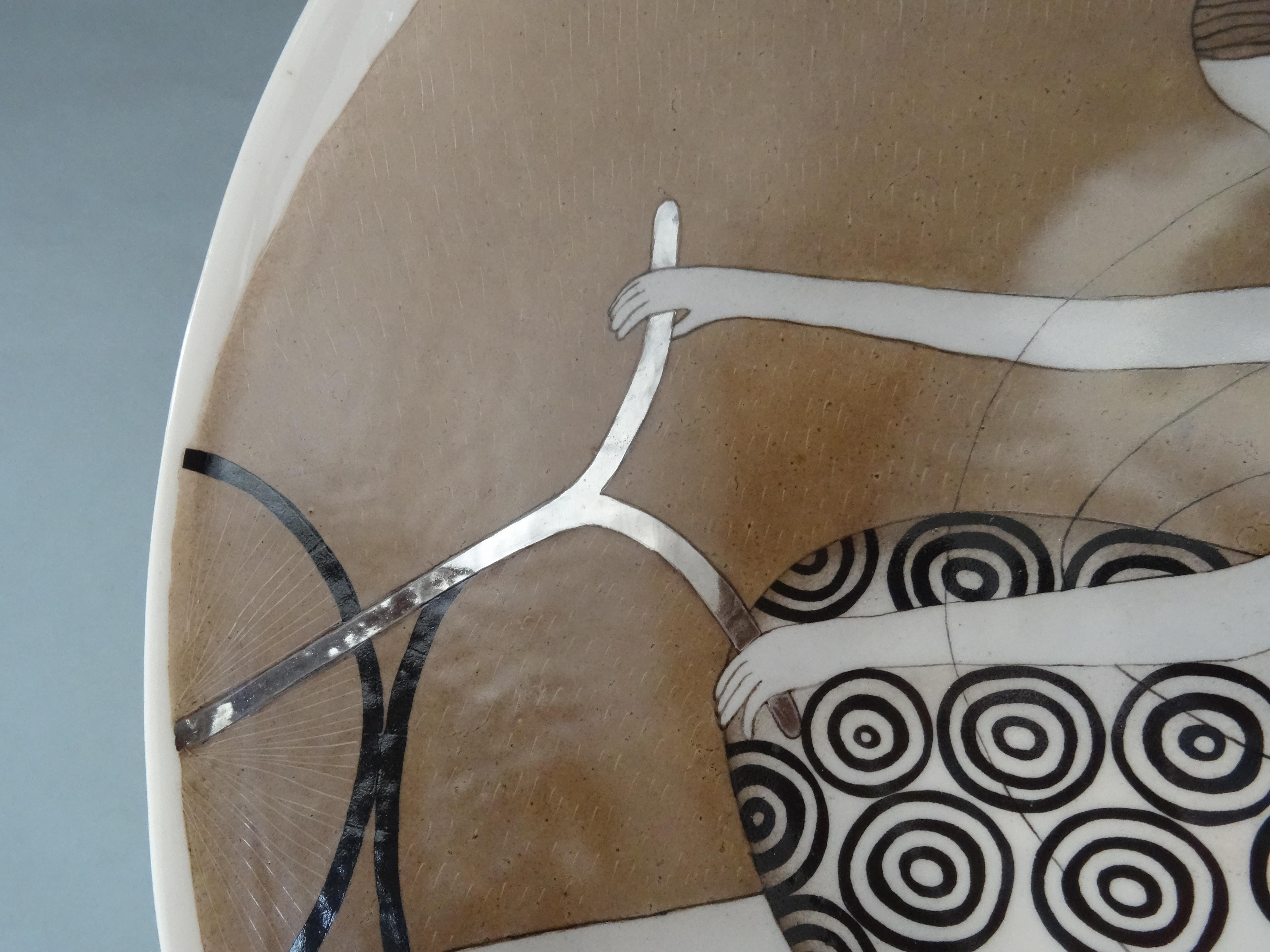 Porzellanteller - Ein Radfahrer mit Flügeln. 2016, d 36 cm

Dieser Porzellanteller, der eine Figur in Bewegung darstellt, ist ein bemerkenswertes Kunstwerk, das Laune und Kreativität vereint. Der aus zartem Porzellan gefertigte Teller hat einen