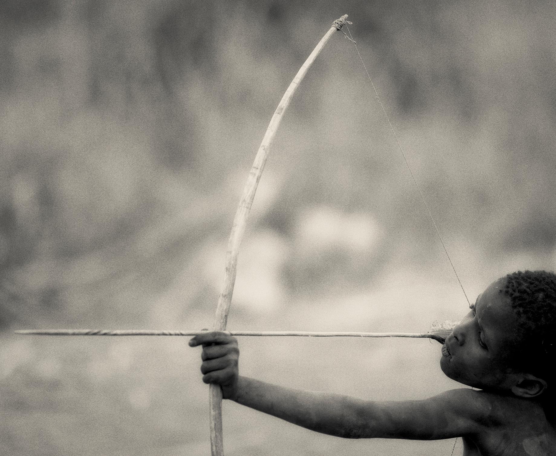 'HADZABE, ' Tanzanian Child with Bow, Black and White Photograph by Nicol Ragland 1
