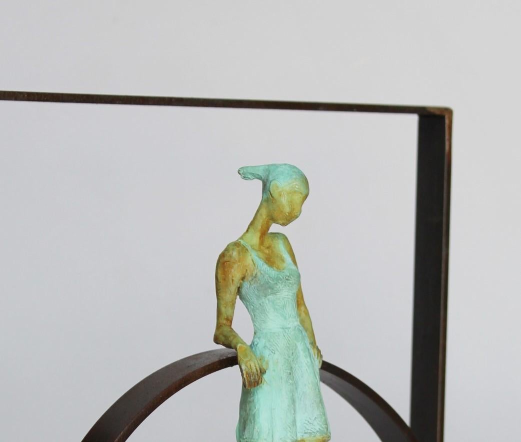 Martonas Circel ist eine Bronzeskulptur mit grüner Patina, die mit einem Stahlsockel verbunden ist. Die Auflage beträgt 50 Stück. Dies ist eine Wandskulptur und kann auf einer Fläche stehen. Joan fängt die Stimmung eines Mädchens ein, das einen
