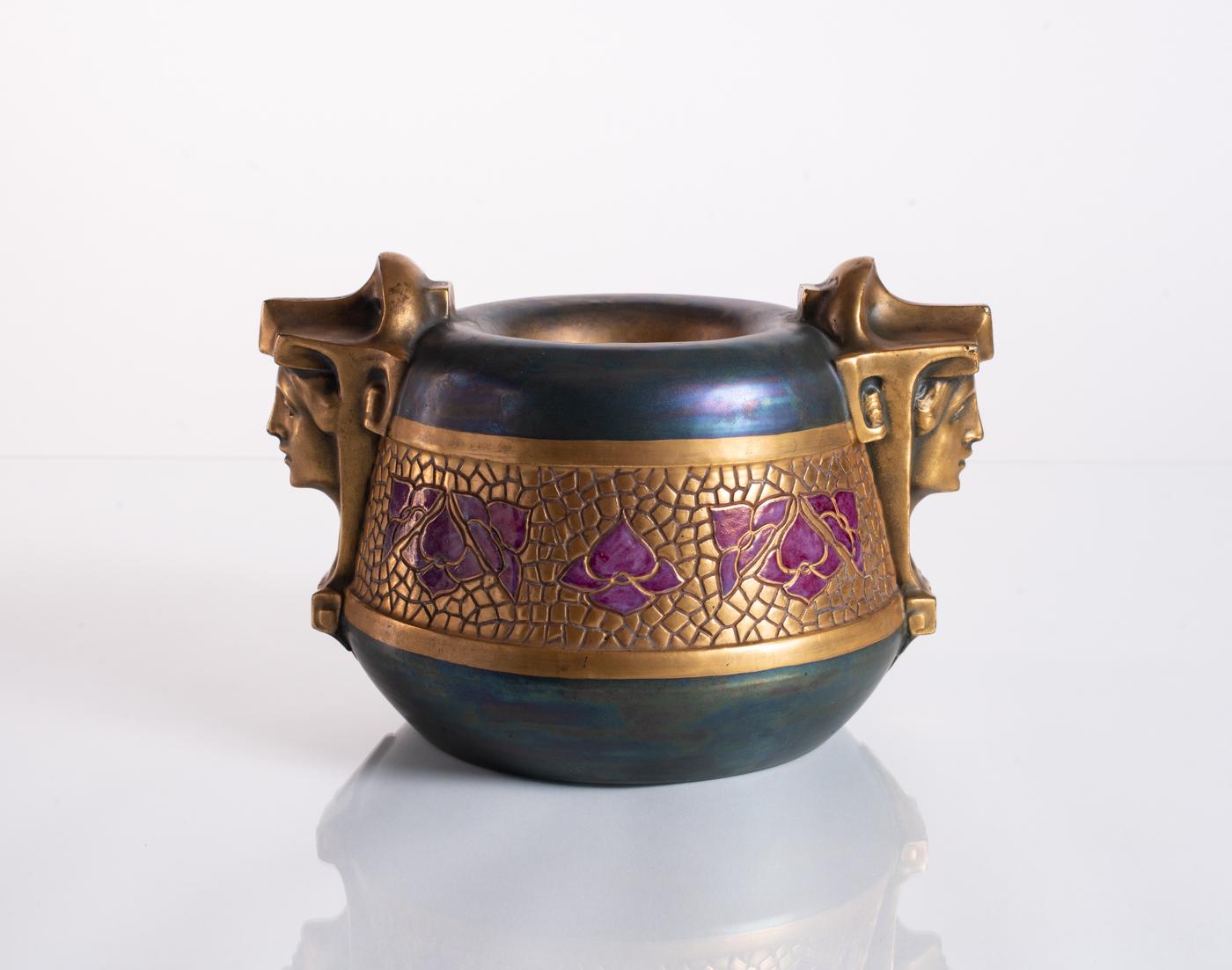 Unique earthenware bowl featuring a pair of golden Egyptian sphinxes and stylized purple flowers in an incised pattern, with an iridescent glaze of rich green, blue, and purple hues. Stamped in the base, and numbered.

Already well established