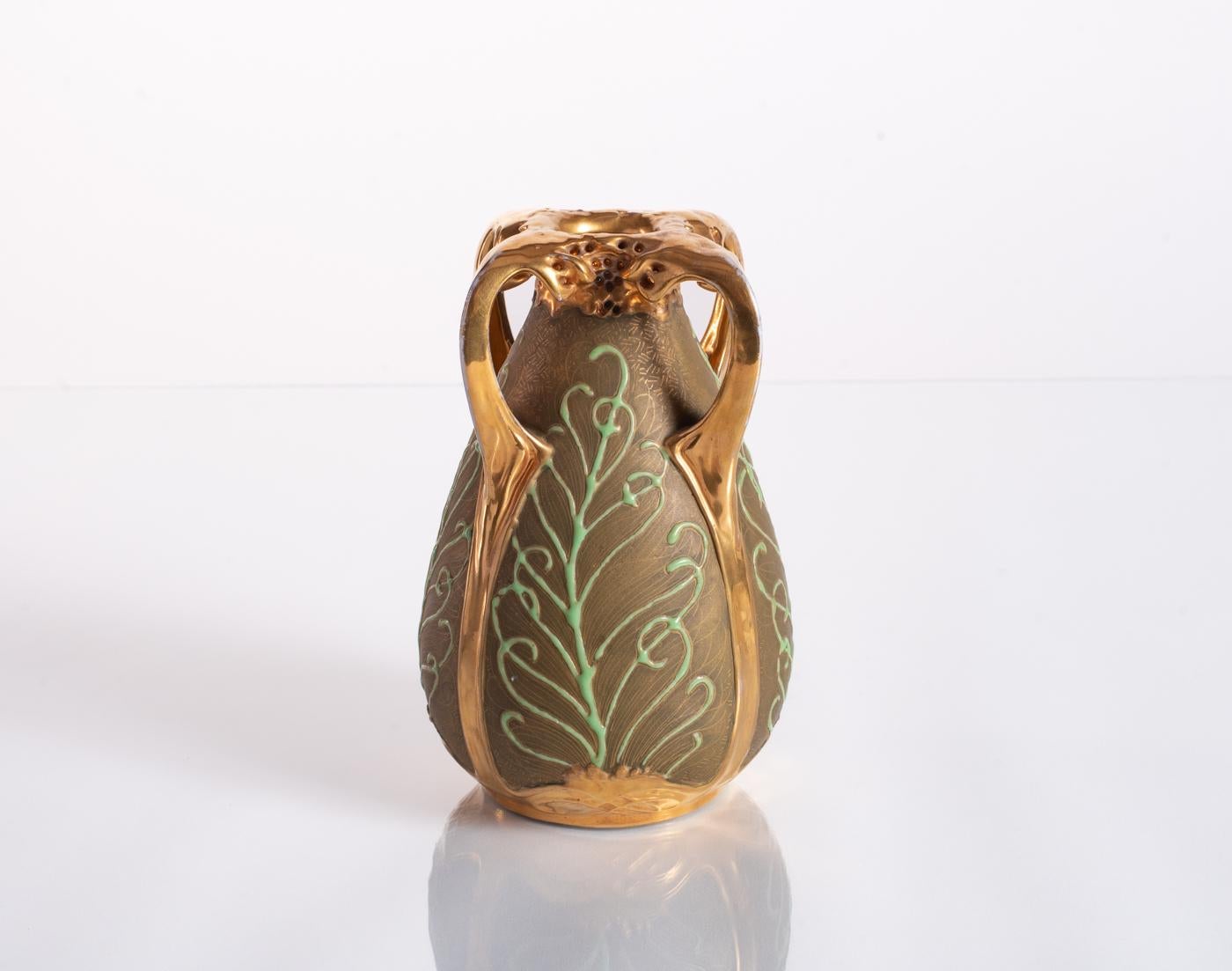 Ceramic vase designed by Paul Dachsel for Amphora featuring delicate gold cross-hatching and relief elements to evoke peacock feathers. Polished gold glaze around mouth, on handles, and base relief. A design attributed to Paul Dachsel; stamped