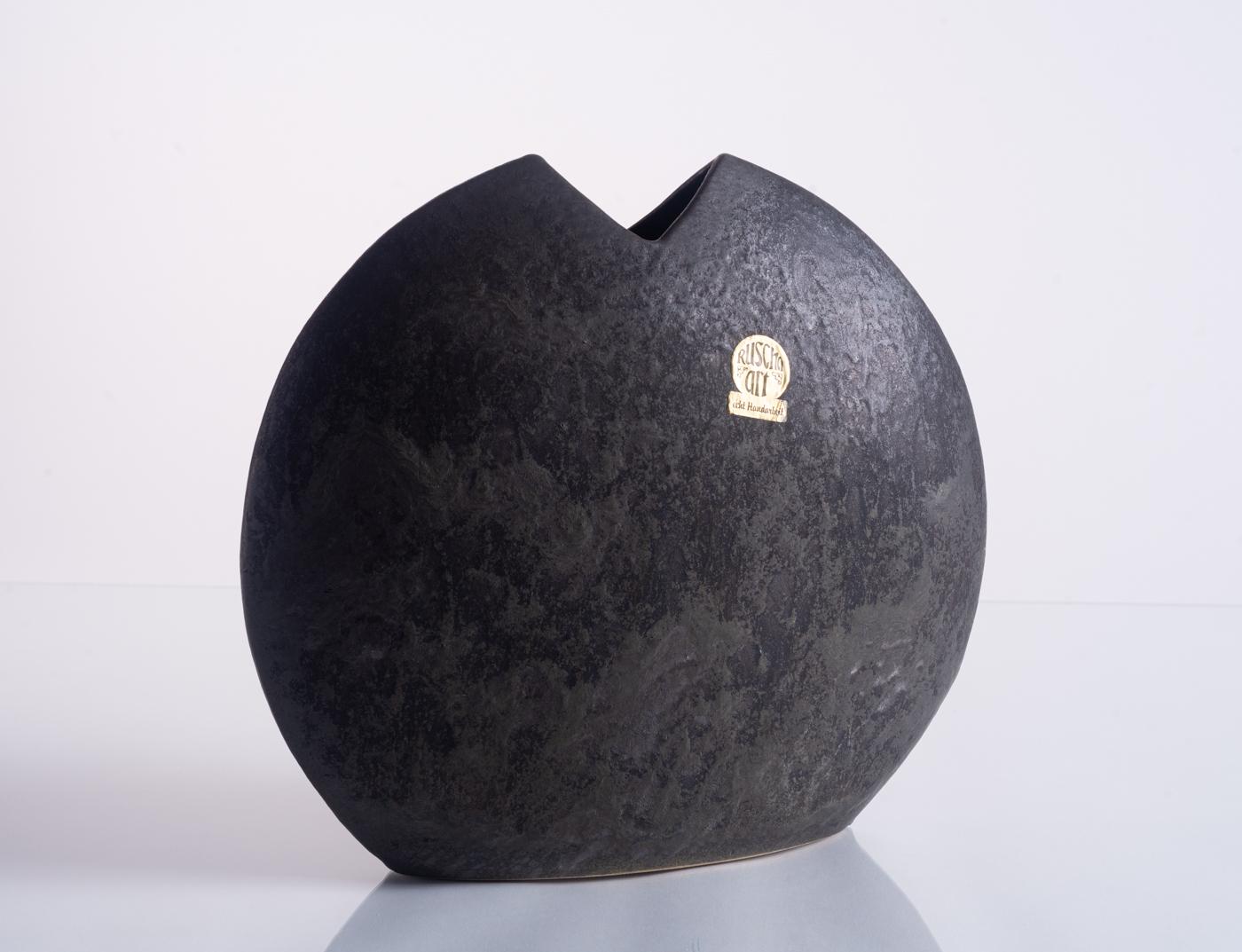 This Brutalist ceramic vase from Ruscha Keramik was charismatically called a Moonvase due to its circular shape, mottled texture, and deep purple, gray, and black glazing. Numbered in the base; the Ruscha Art sticker is original. Form A-1.

Ruscha