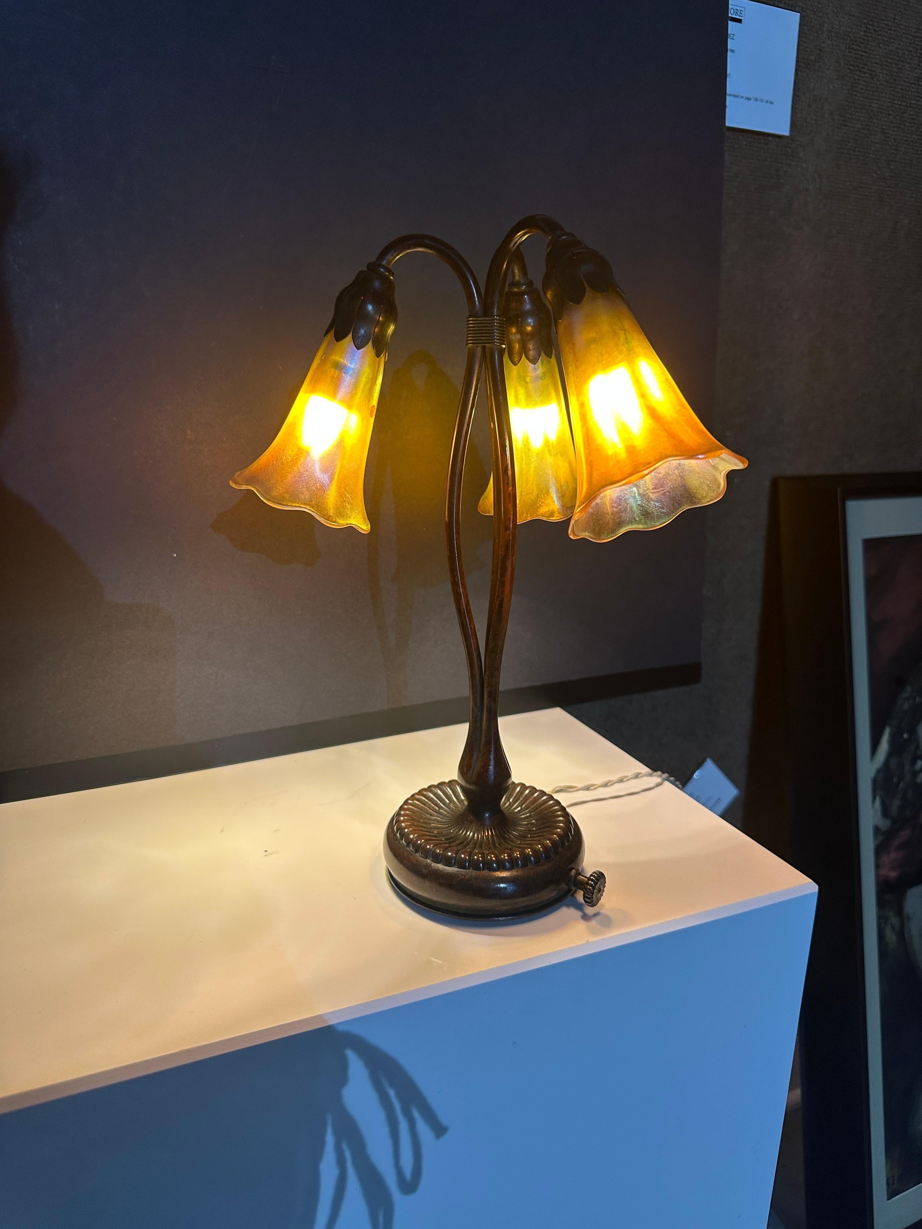 Three Light LILY Table Lamp, 1900s
Favrile glass, patinated bronze, two shades
engraved L.C.T. F
Avrile base impressed TIFFANY STUDIOS NEW YORK319
13 in