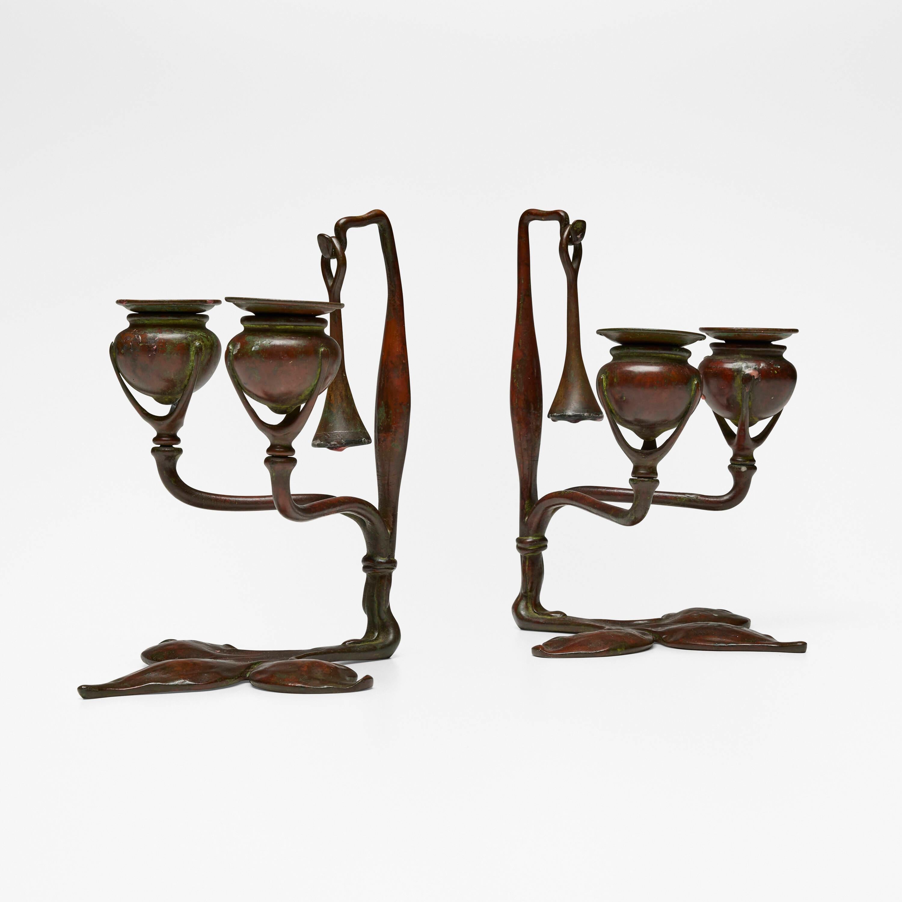 Tiffany Studios
Fleur-de-lis candleholders with snuffers, set of two
c. 1910
patinated bronze
8¾ h × 6⅜ w × 7⅜ d in (22 × 16 × 19 cm)

Impressed to underside of each example 'TIFFANY STUDIOS NEW YORK' and 'TIFFANY STUDIOS NEW YORK