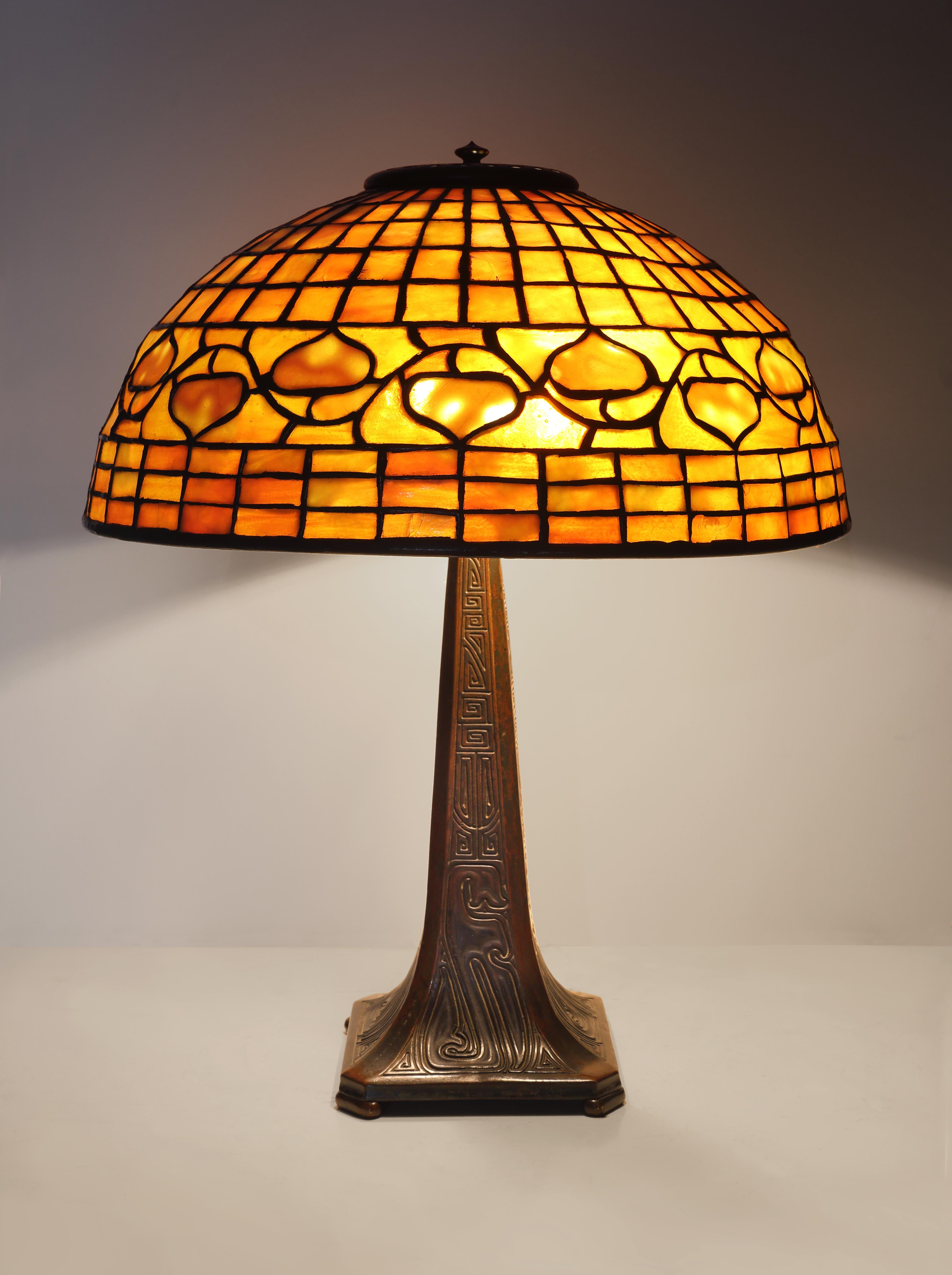 Tiffany Studios
Schreibtischlampe "Vine Border", um 1905
mit "chinesischem" Sockel, Bleiglas, patinierte Bronze
Farbton eingeprägt "Tiffany Studios, New York, 1420".
Sockel eingeprägt "Tiffany Studios, New York, 535".
18 Zoll hoch, 14 Zoll