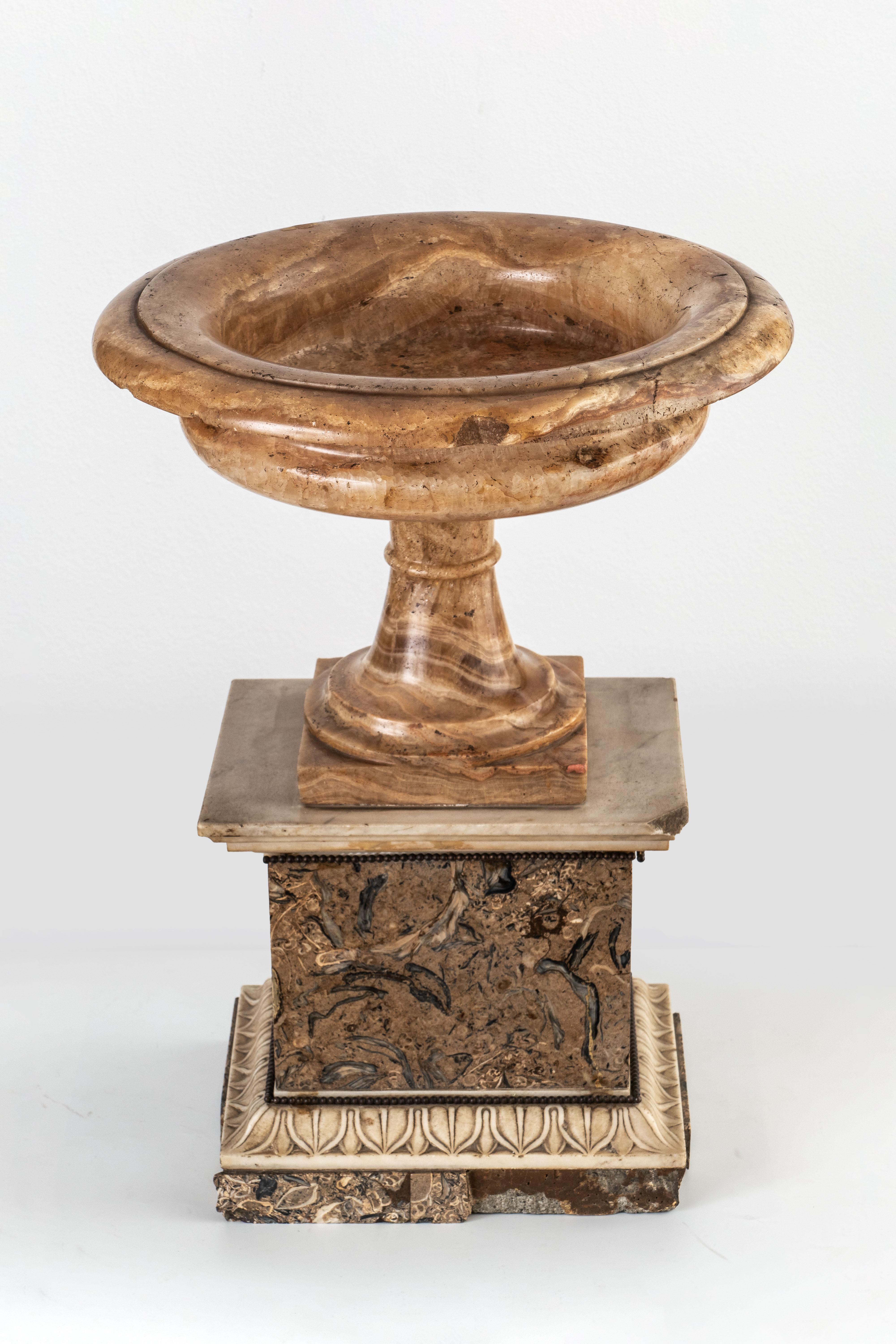 NEOKLASSISCHE TAZZA
Rom, 19. Jahrhundert
Alabastro fiorito und Lumachello-Marmor
H 44 cm, T 33 cm
H 17 1/4 T 13 Zoll
