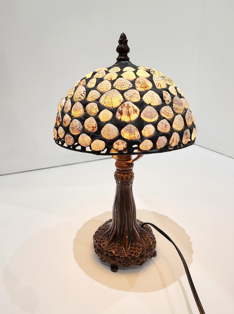 14-inch high cockle shell and bronze table lamp from Richard Hoosin Studio with three-way LED bulb. Inscribed and dated 98 on top of shade.  