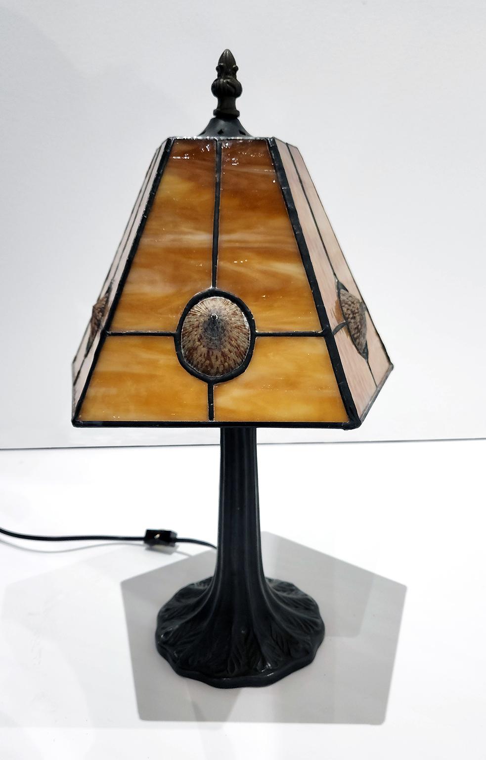 17-inch high, five-sided limpet shell, stained glass and bronze table lamp from Richard Hoosin Studio with incandescent bulb. Inscribed Hoosin 5P9851 and dated 98 on top of shade.  