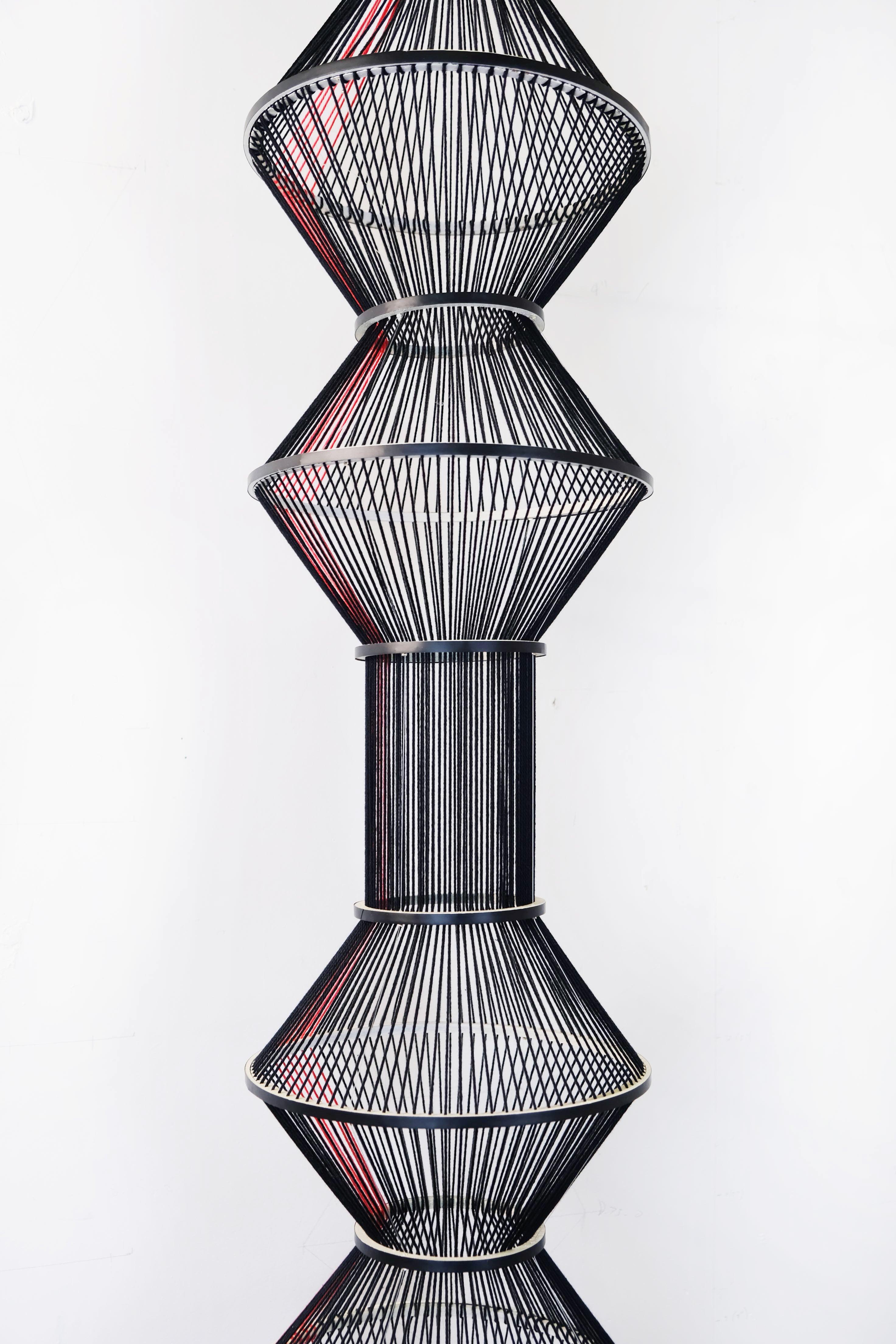 This bold black and red contemporary abstract sculpture is an original artwork by Peruvian-Canadian artist Sofia Escobar. Hundreds of pieces of thread and wool have been carefully handwoven in a delicate exploration of light and form. This dynamic