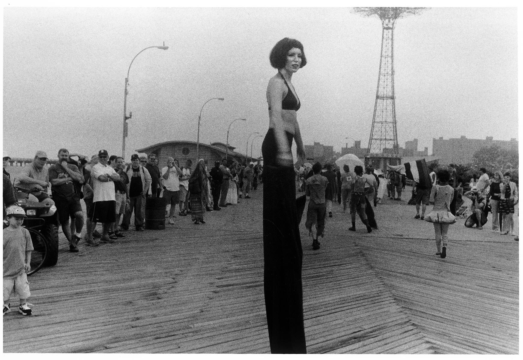Harvey Stein  Black and White Photograph - Stilt Walker in Mermaid Parade, Cosney Island, Beach, New York 