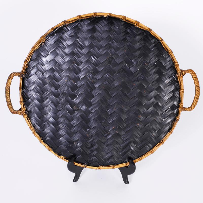 Handmade tray or basket with a faux bamboo border, two handles and a folksy parrot painted over a herringbone weave.