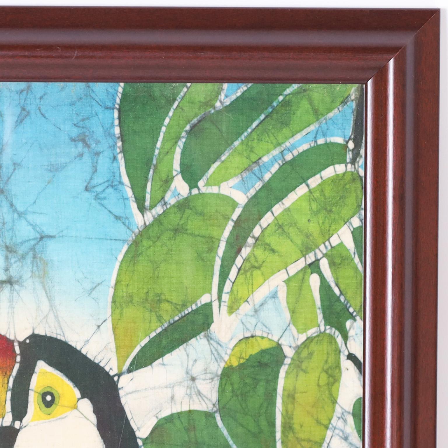 Transportierendes Kunstwerk eines Tukans in einem Baum, fachmännisch ausgeführt in einer Batiktechnik auf Seide und undeutlich signiert. Präsentiert unter Glas in einem Holzrahmen.