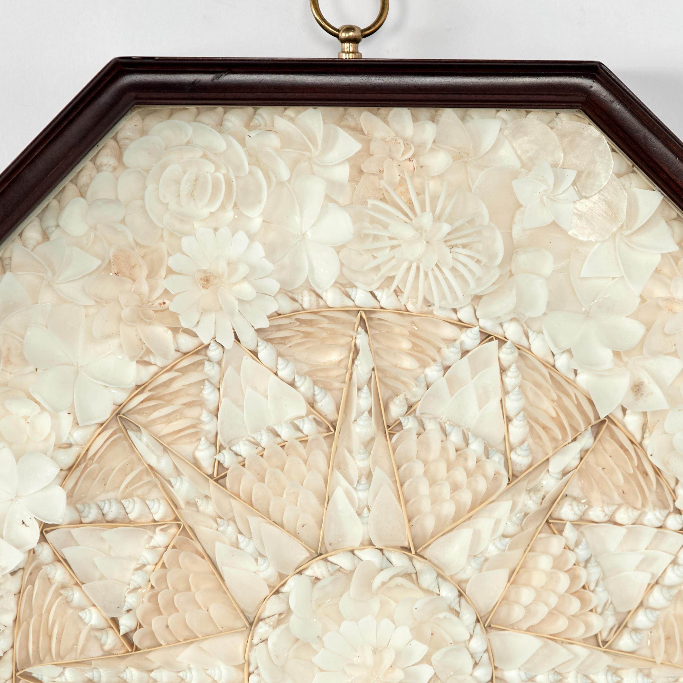 Enchanting  sailors valentine handcrafted with exotic white seashells in an extravagant star form composition and presented in an octagon mahogany shadow box, by Authentic Models. 