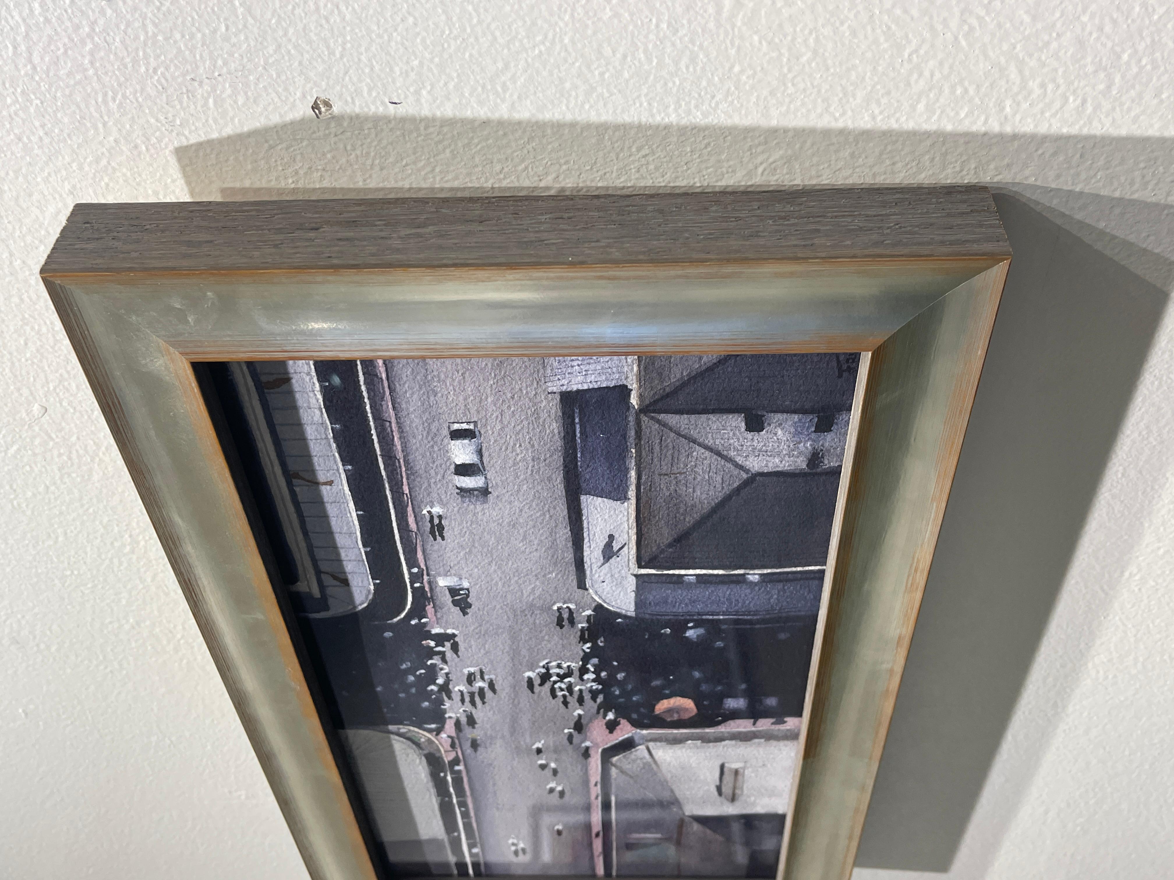 French Quarter Overhead von Sean Friloux zeigt das French Quarter aus der Vogelperspektive und eine sich versammelnde Second Line Prozession. Dieses Aquarell ist in einem silberfarbenen Rahmen gerahmt.
