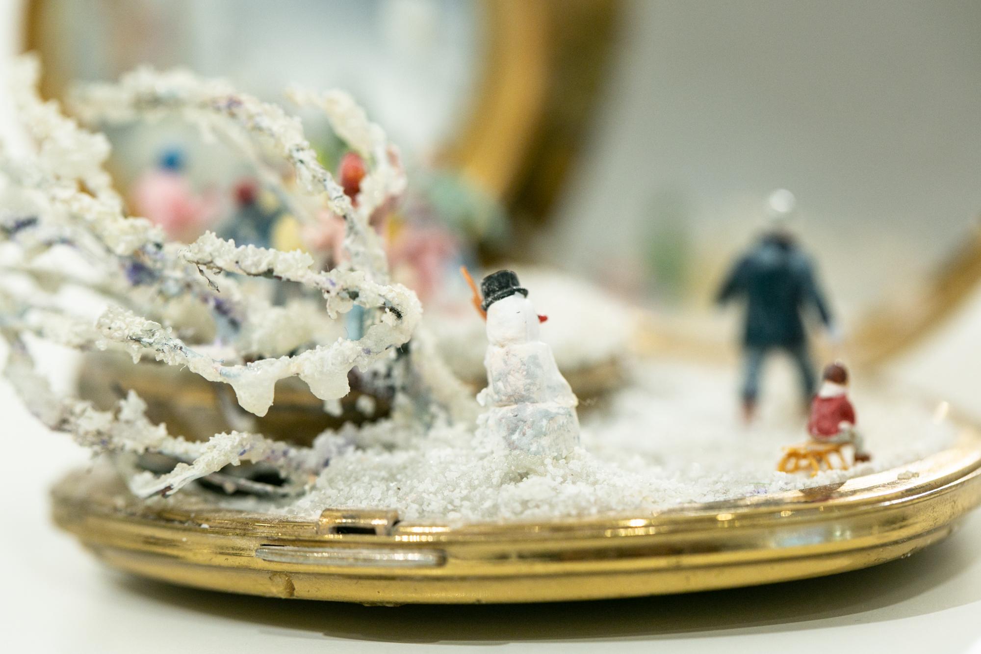 Esta escultura en miniatura de espejo compacto de una escena invernal nevada titulada 