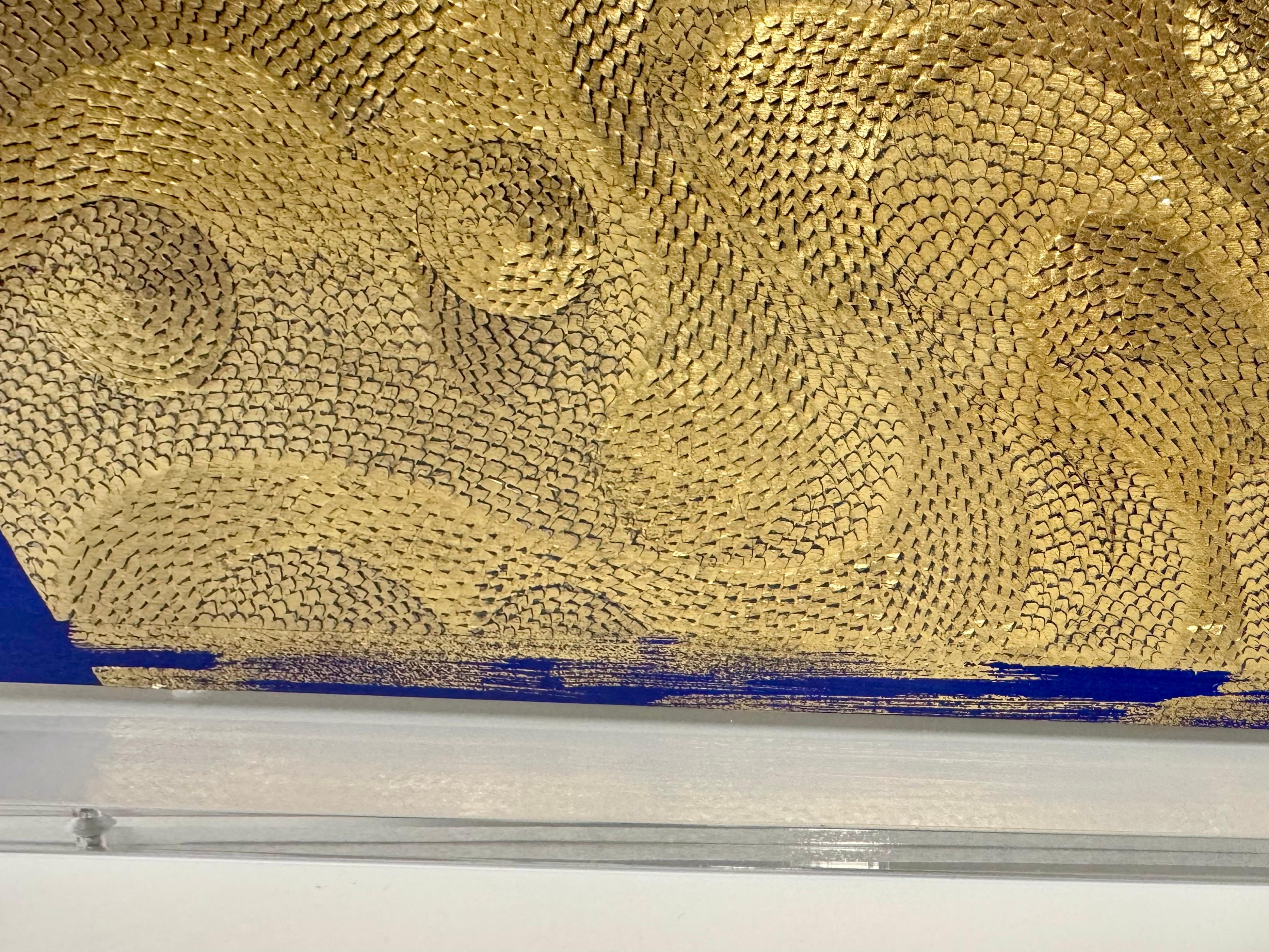 Carta di cotone scolpita incorniciata con foglia d'oro su sfondo blu 