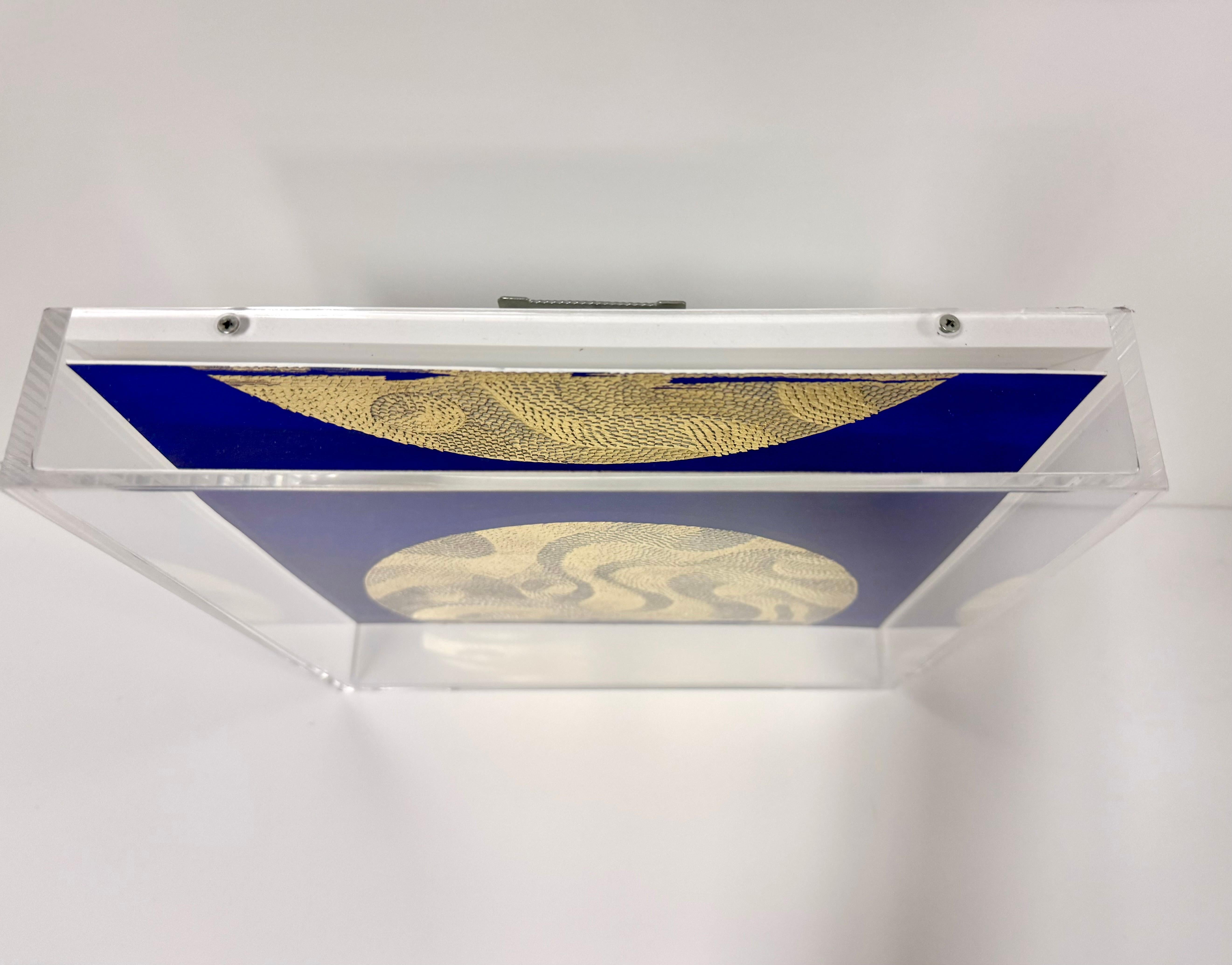 Carta di cotone scolpita incorniciata con foglia d'oro su sfondo blu 
