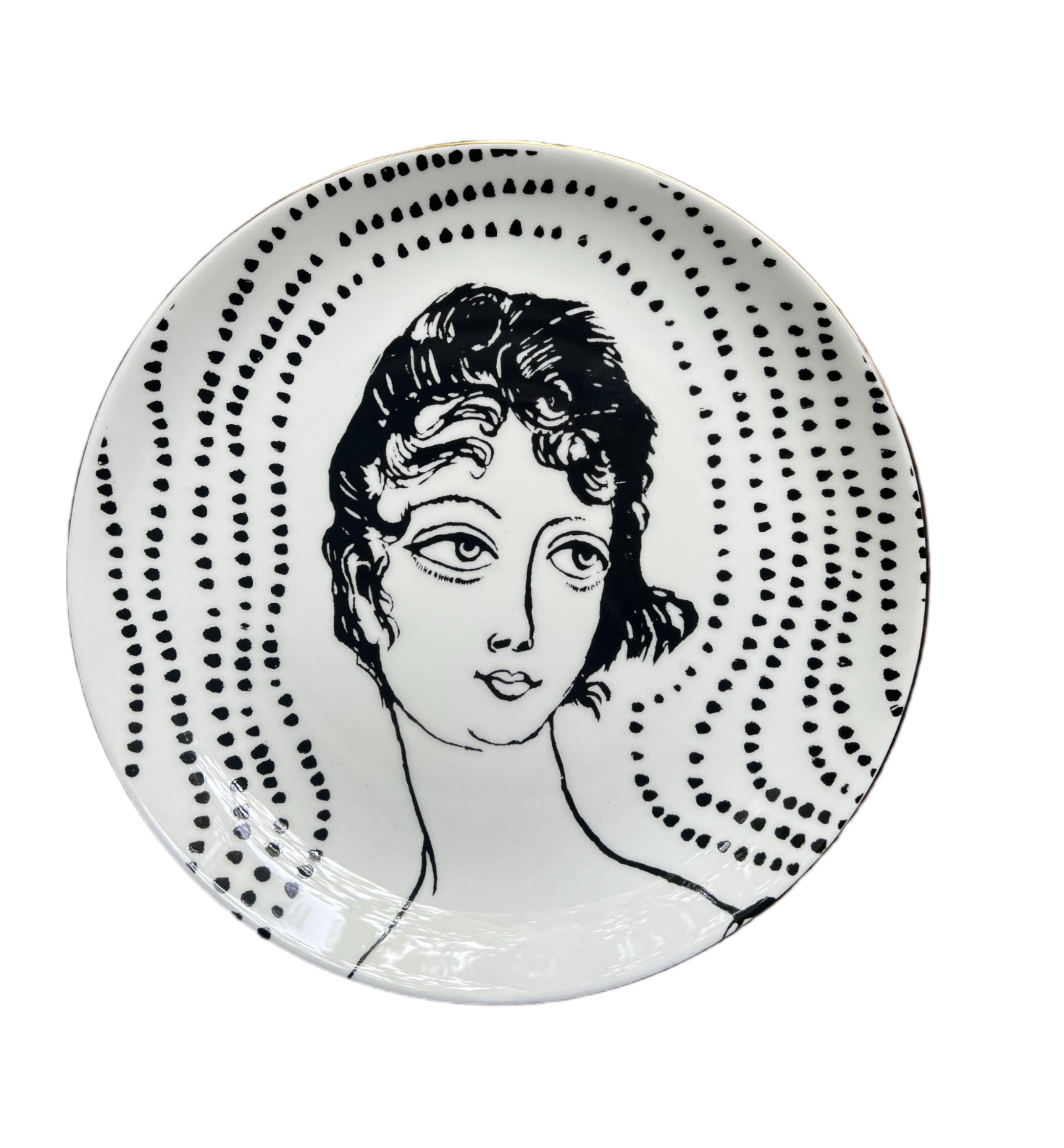 bone china with lustre rim
21 cm diameter
Grayson Perry hallmark on the back.

These decorative plates are inspired by the artwork The Great Beauty, 2024. The original piece is a cabinet heavily decorated with ceramic female portraiture, created in