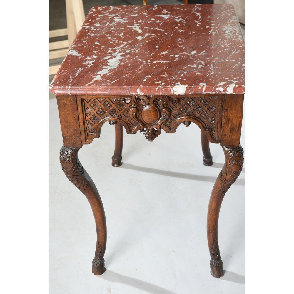 Middle game table Regency period in natural wood with a nice patina. It is decorated on the belt with squares and a central medallion with the date 1732. It stands on finely carved curved legs ending in hooves. White veined red marble top. 18th