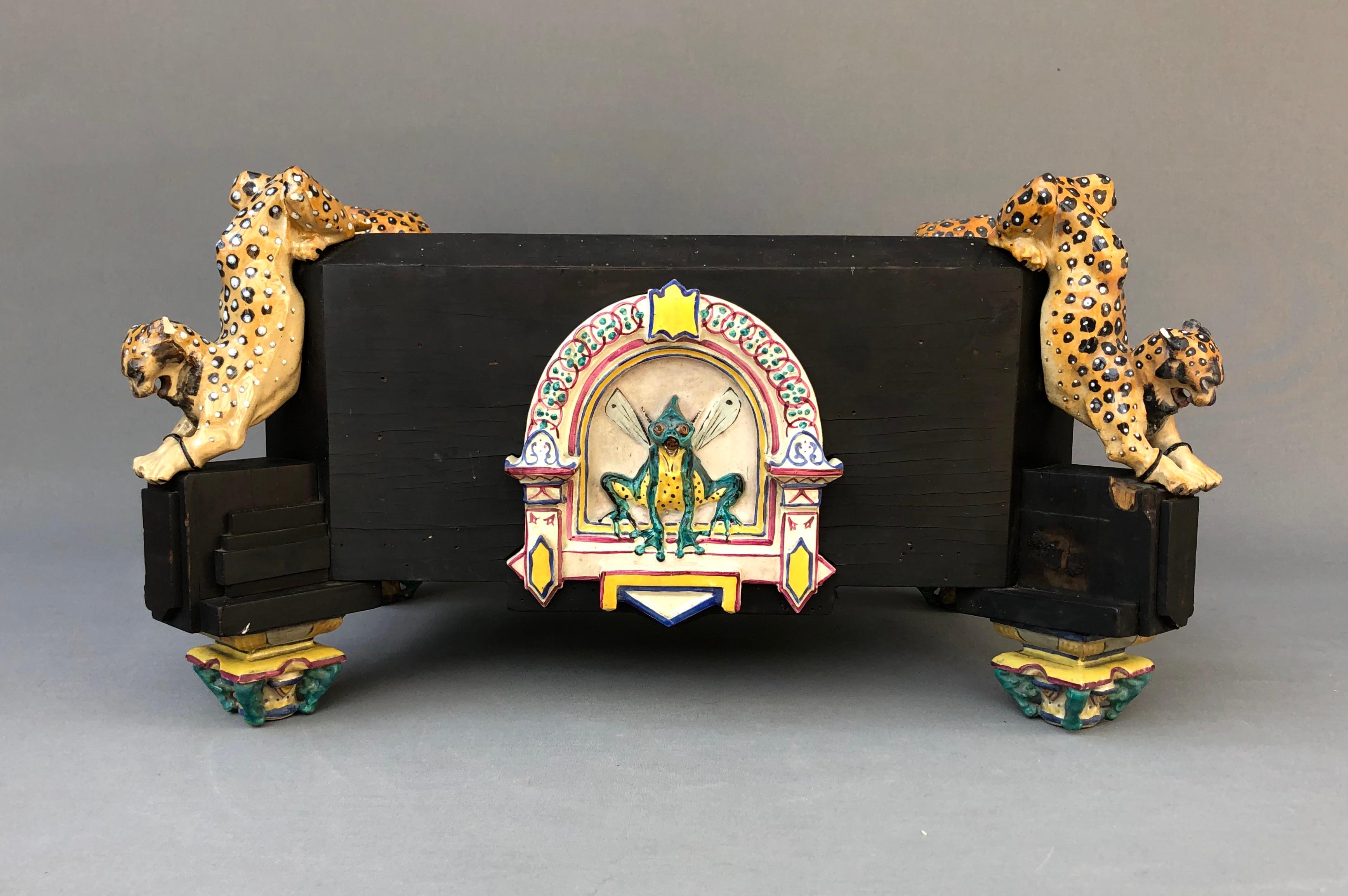 After Charles-Guillaume DIEHL (1811-1885) & Emmanuel FRÉMIET (1824-1910)
Blackened wooden planter decorated with arched felines, the central niche decorated with a fantastic creature in polychrome ceramic.
The feet feature polychrome ceramic Chinese