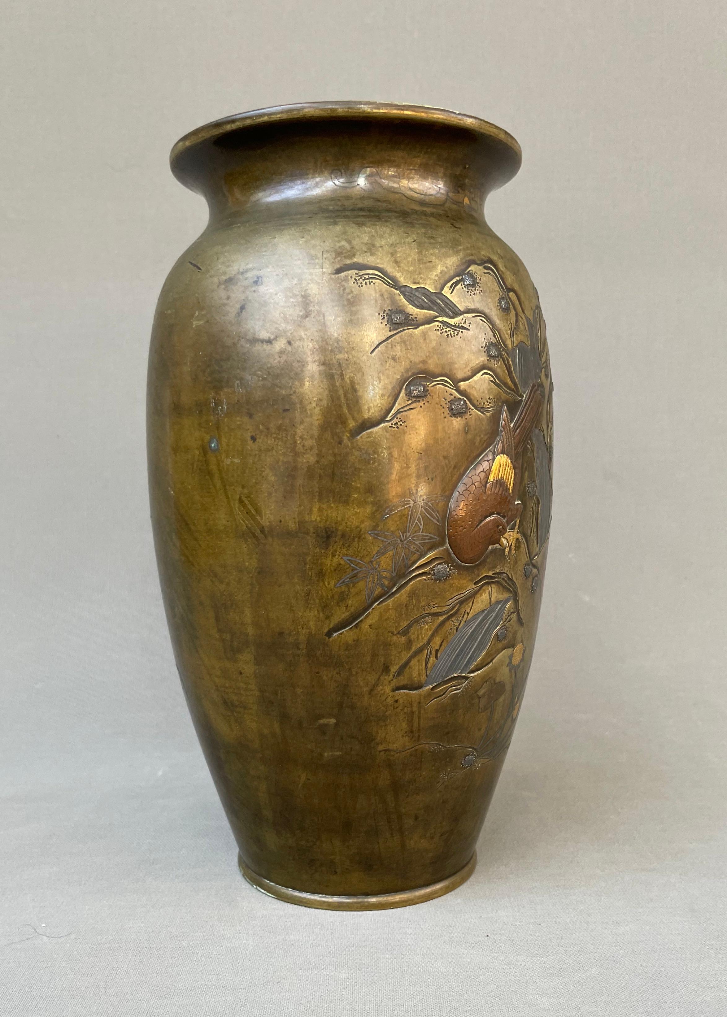Japon, période Meiji.  Vase en bronze avec incrustations d'or, de cuivre et d'argent, décoré sur une face d'un oiseau dans un paysage montagneux, sur l'autre d'insectes, de fleurs et de feuillages.  A nettoyer, le fond est percé, sinon bon état. 