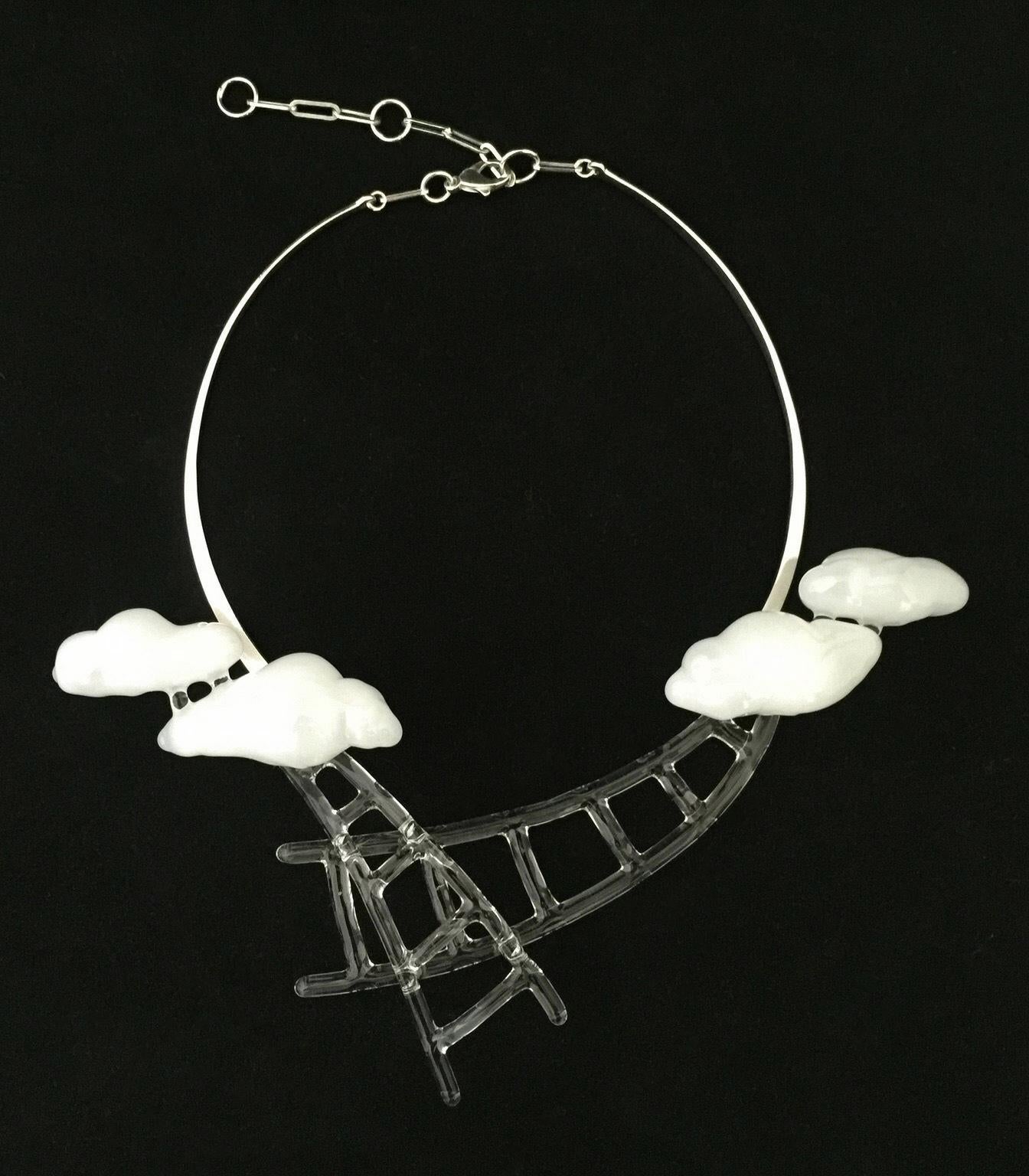"Stairway III" by Eunsuh Choi is a glass and silver necklace featuring clouds and ladders. The glass is flameworked borosilicate. It is of variable dimensions. 

Eunsuh Choi has exhibited internationally including at the European Museum for Modern