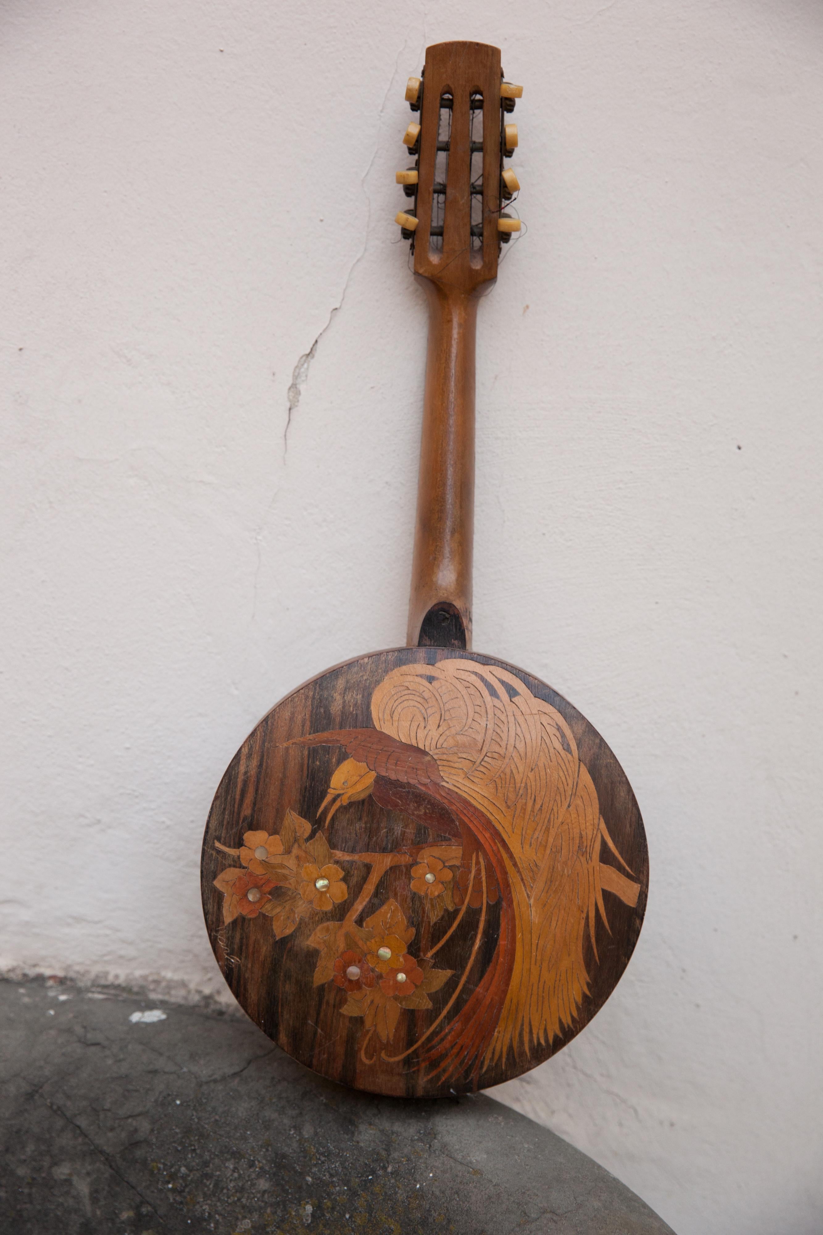 Banjo. Zu restaurierendes Musikinstrument der Art Deco-Ära aus Intarsienholz.

Signiert auf dem Griff Achille Jacomoni, die Unterschrift ist mit der Technik der Pyrografie gemacht.

MATERIALIEN: Holz, Metall, Pergament.
Ein Vogel mit exotischen und