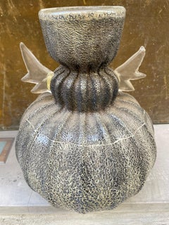 Jarrón artístico de vidrio iridiscente con asas en forma de hoja. Italia, hacia 1960-80